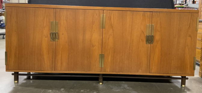 BAKER FURNITURE MCM Credenza Server Console: Console appears to be BAKER FURNITURE (no apparent markings). Piece is mid century modern. Base has 6 cylindrical shaped wooden feet with brass caps. Piece has 2 double cabinet doors each with danglin