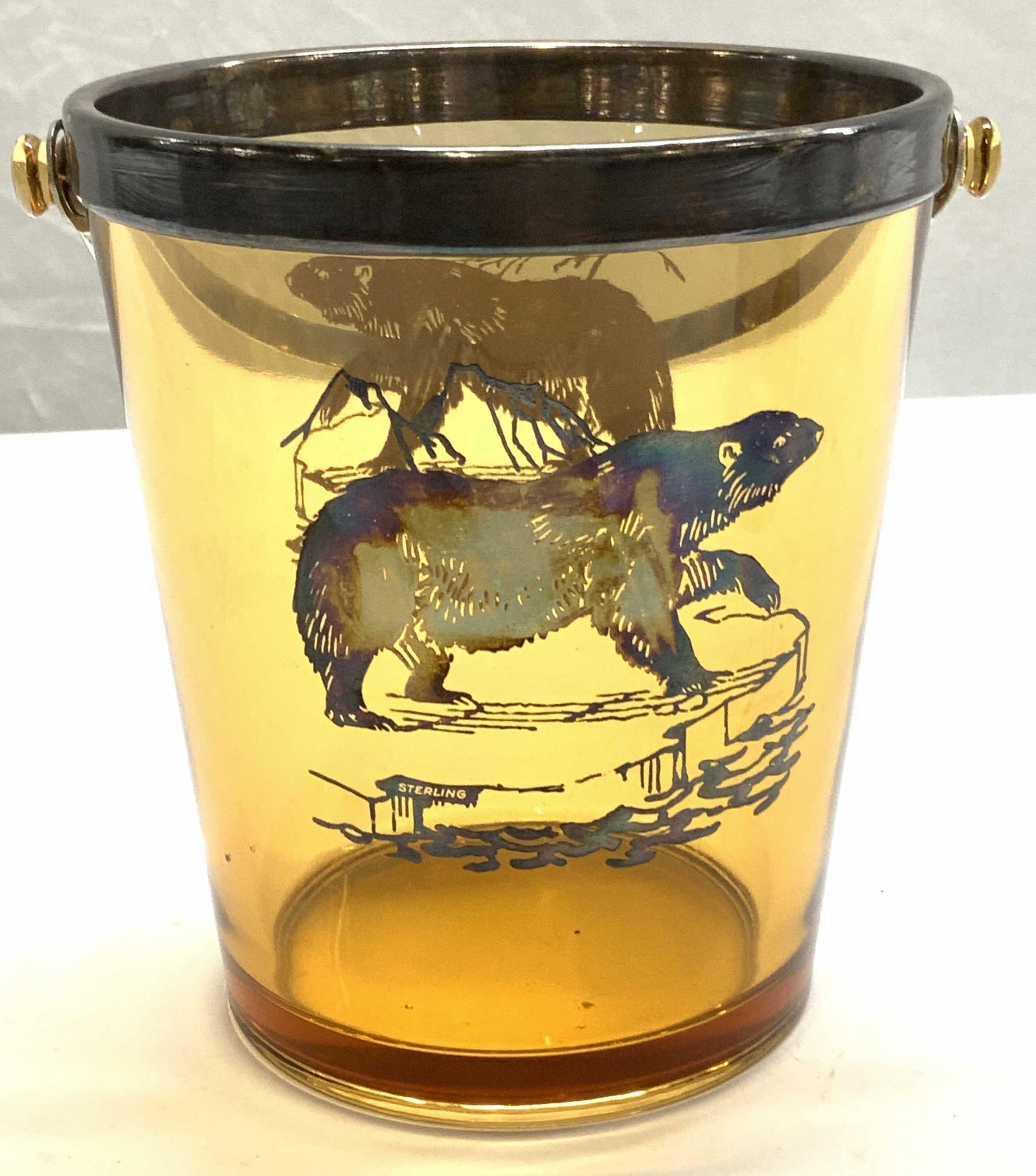 Sterling Silver Amber Glass Bear Ice Bucket: Sterling silver overlay amber glass ice bucket with bear motif. Marked sterling. Measures approx. 5.25 x 5.75 inches. Some surface wear consistent with exposure. Sterling silver, sterling silver overl