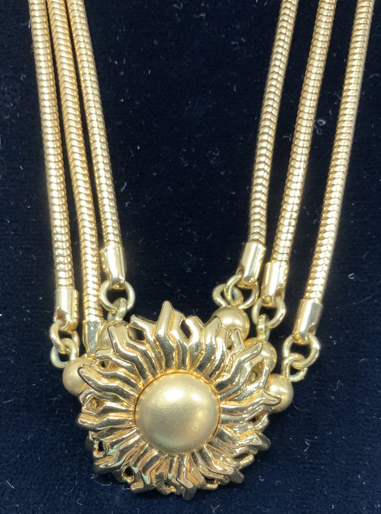 MONET Multi Snake Chain w Sunburst Pendant: Signed Monet Choker Necklace. Gold Tone with 3 snake chains and a center sunburst stationary pendant. Adjustable length, 12-14 in. L . Pendant measures 1 in. Signed Monet Jewelry, Gold tone jewelry, M