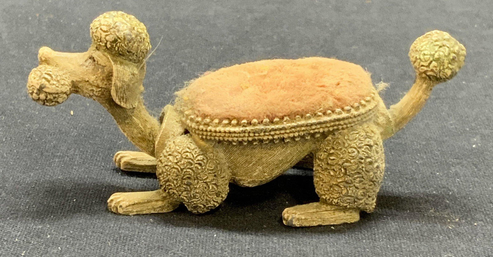 Vintage FLORENZA Metal Poodle Pin Cushion: Vintage FLORENZA metal poodle pin cushion, tail wags and head bobs, has mechanism. Surface wear consistent with exposure. Trademarked to underside. Measures approx. 3.25 x 1.25 x 1.25 inches. FLORENZA