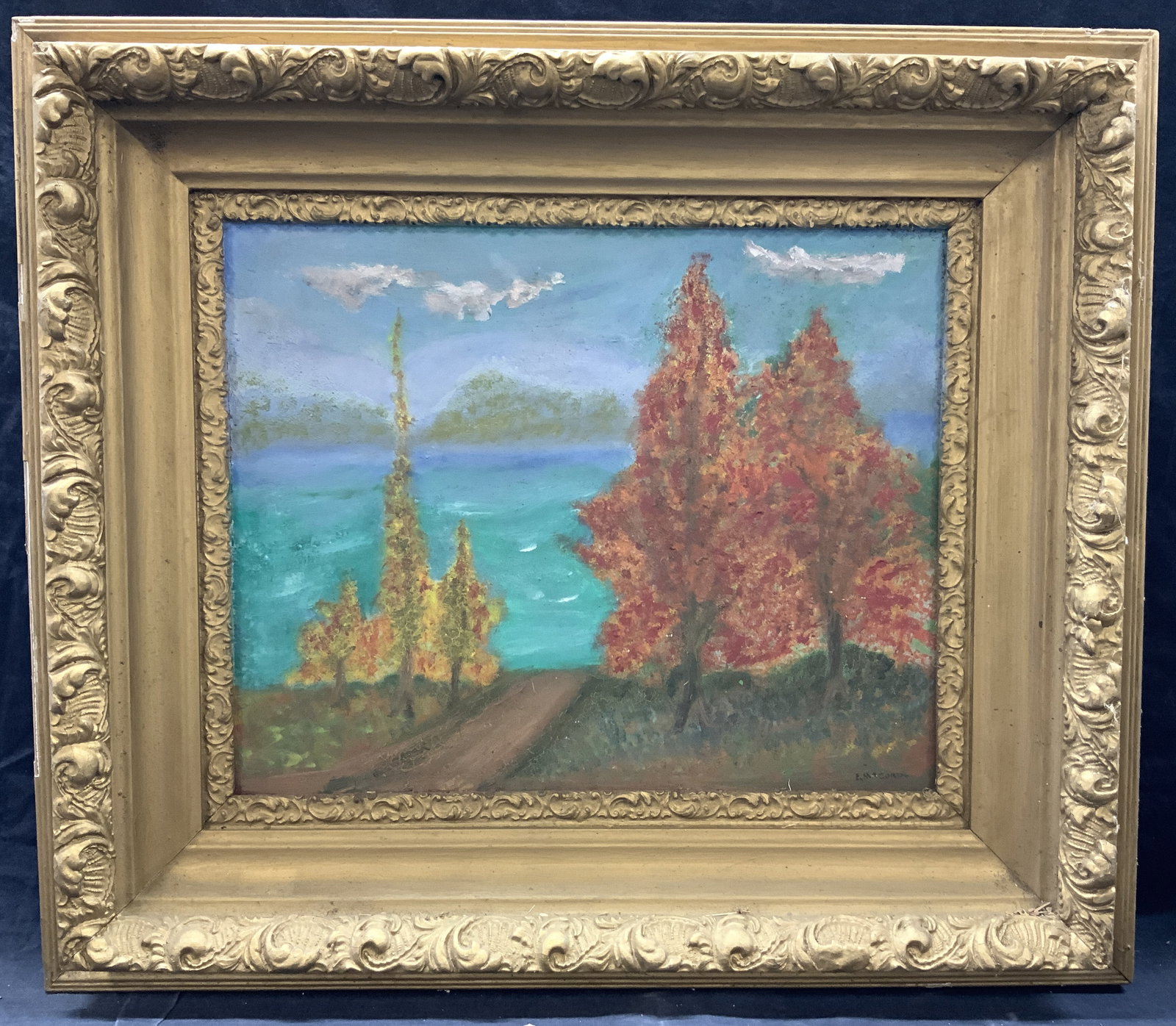 E.M.Cord Signed Vintage Landscape Oil Painting: Signed on lower right corner E.M.Cord Depicts trees within a blue and teal landscape Framed in gold painted wooden and plaster made frame with ornate scroll designs on outer and inner edges. Approxima