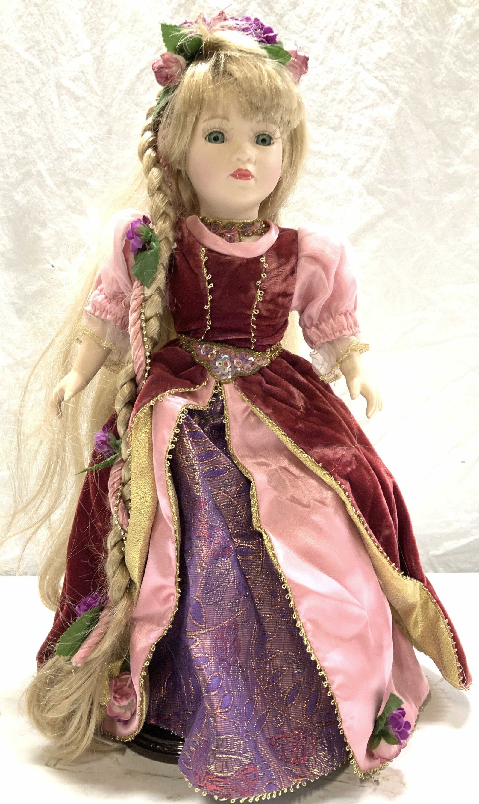 Porcelain Rapunzel Doll on Stand: Princess Rapunzul doll on stand, hand painted porcelain face with long lashes, hazel eyes, and long blond hair. She is is wearing a velvet and satin dress. Her arms and legs are also porcelain. Doll m
