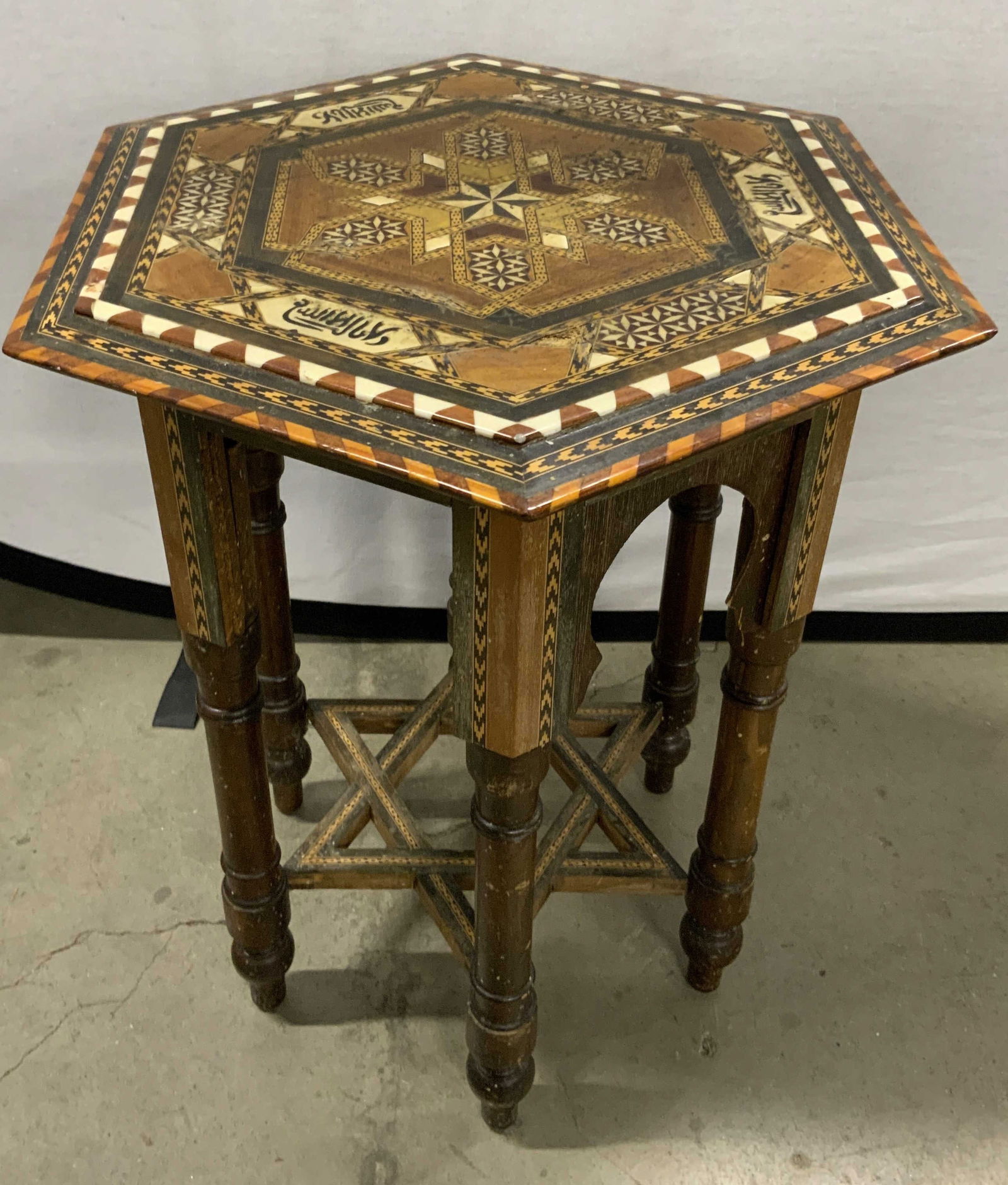 Vntg Hexagonal Handcrafted Inlaid Table, Judaica: A vintage handcrafted inlaid side table. Inlaid wood and bone throughout in various geometric patterns. Lettering to the obverse. Hexagonal form. Star Of David motif stretcher to the legs. Measures ap