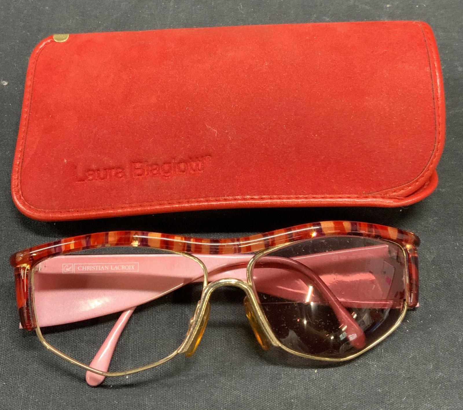 Christian LACROIX Red Frame Sunglasses: Christian LACROIX red acrylic frame sunglasses with Laura BIAGIOTTI case. Designer label on sunglasses arm. Surface wear consistent with exposure. Measure approx. 5 x 5.75 x 2 inches. Christian LACROI