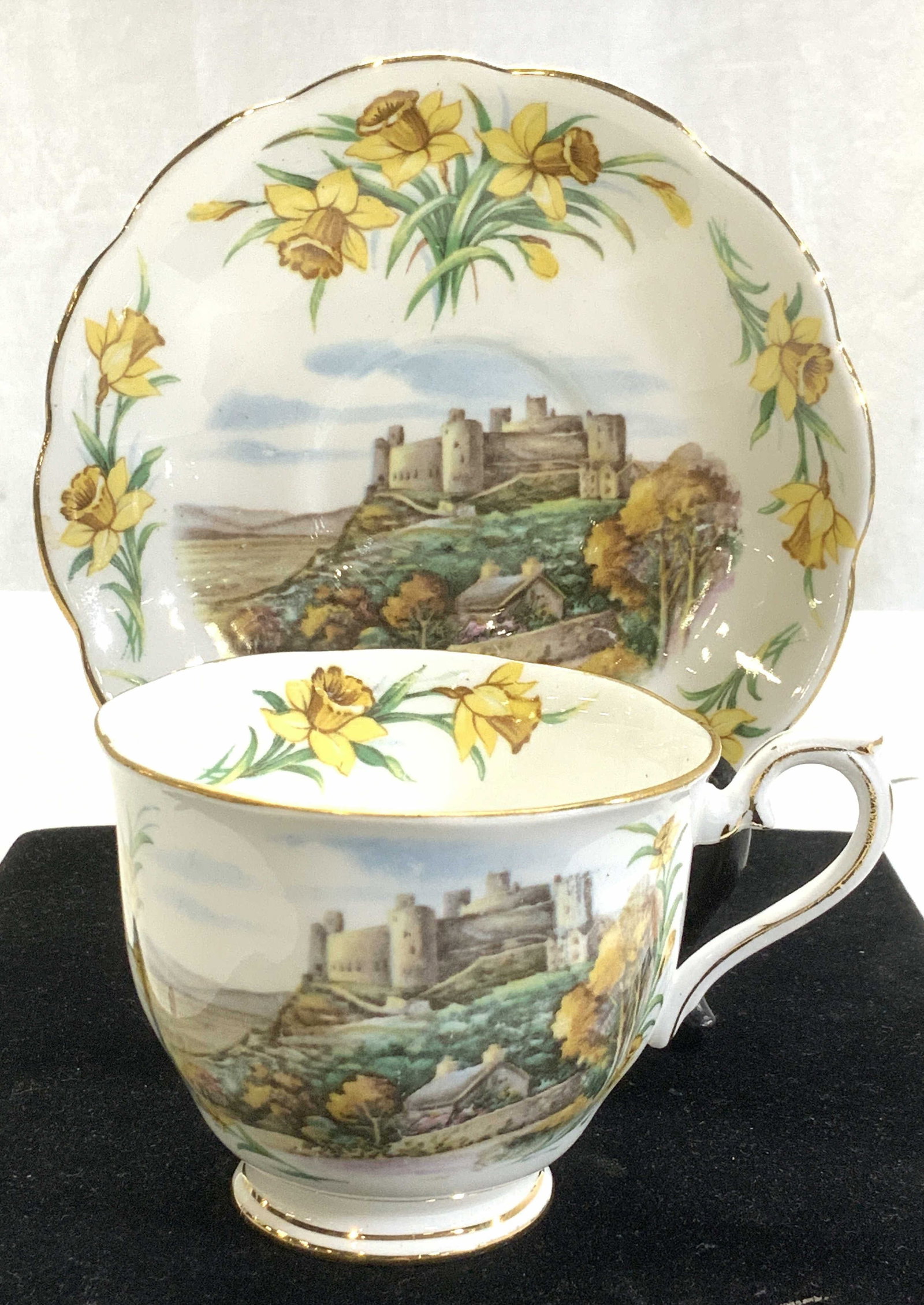 Royal Albert Daffodil Motif China Cup & Saucer: Royal Albert porcelain tea cup and saucer, white bone China with Yellow daffodils and Welsh Castle transferware. Hallmarked ‘Men of Harlech’ this cup is 1 of a series of 6 Traditional British Song