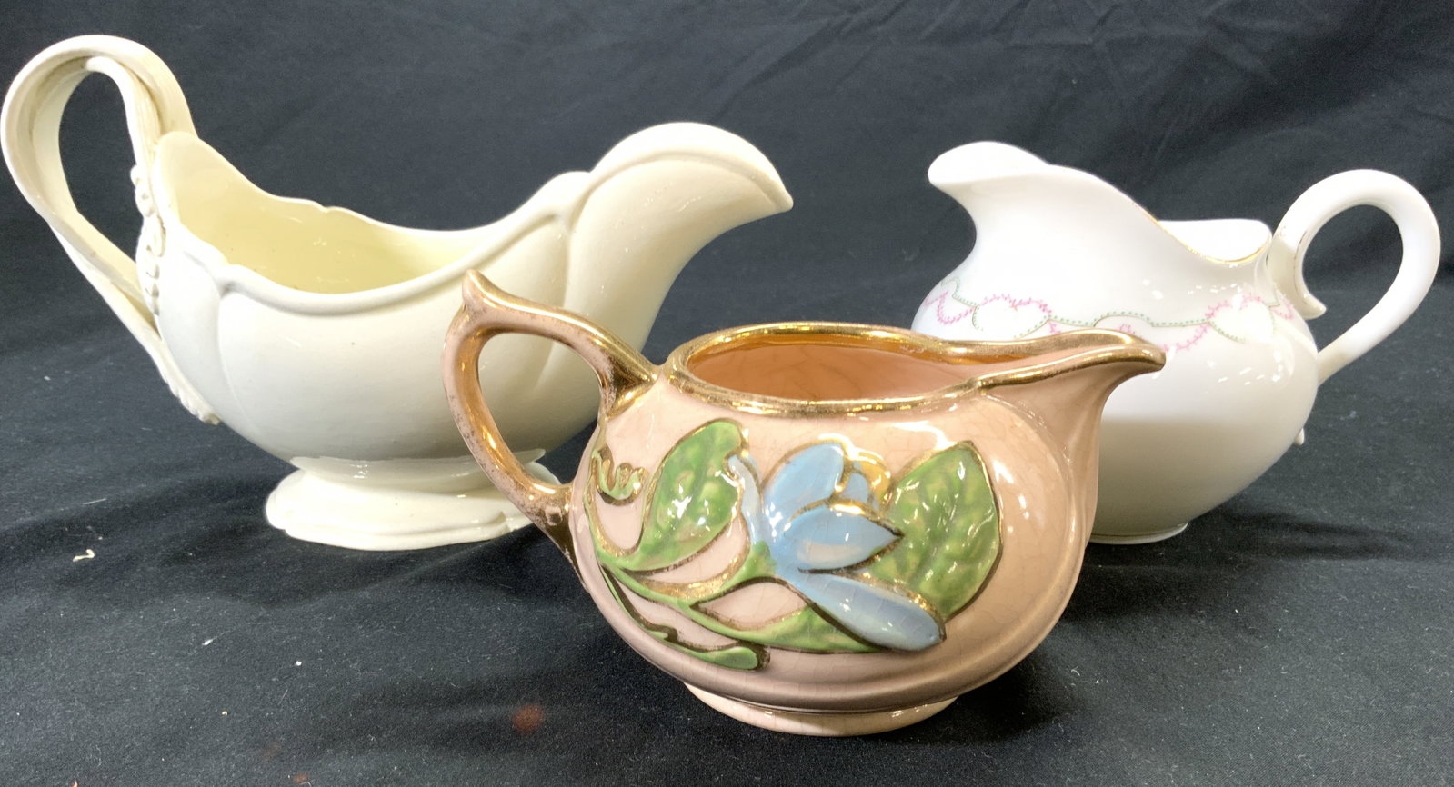 Lot 3 Porcelain Gravy Pourers Creamers Vessels: Lot includes 1 gravy pourer and 2 creamers. Each piece is vintage and Porcelain. Underside of pink toned gilt rim creamer with floral detail has illegible trademark on underside. Largest piece measure