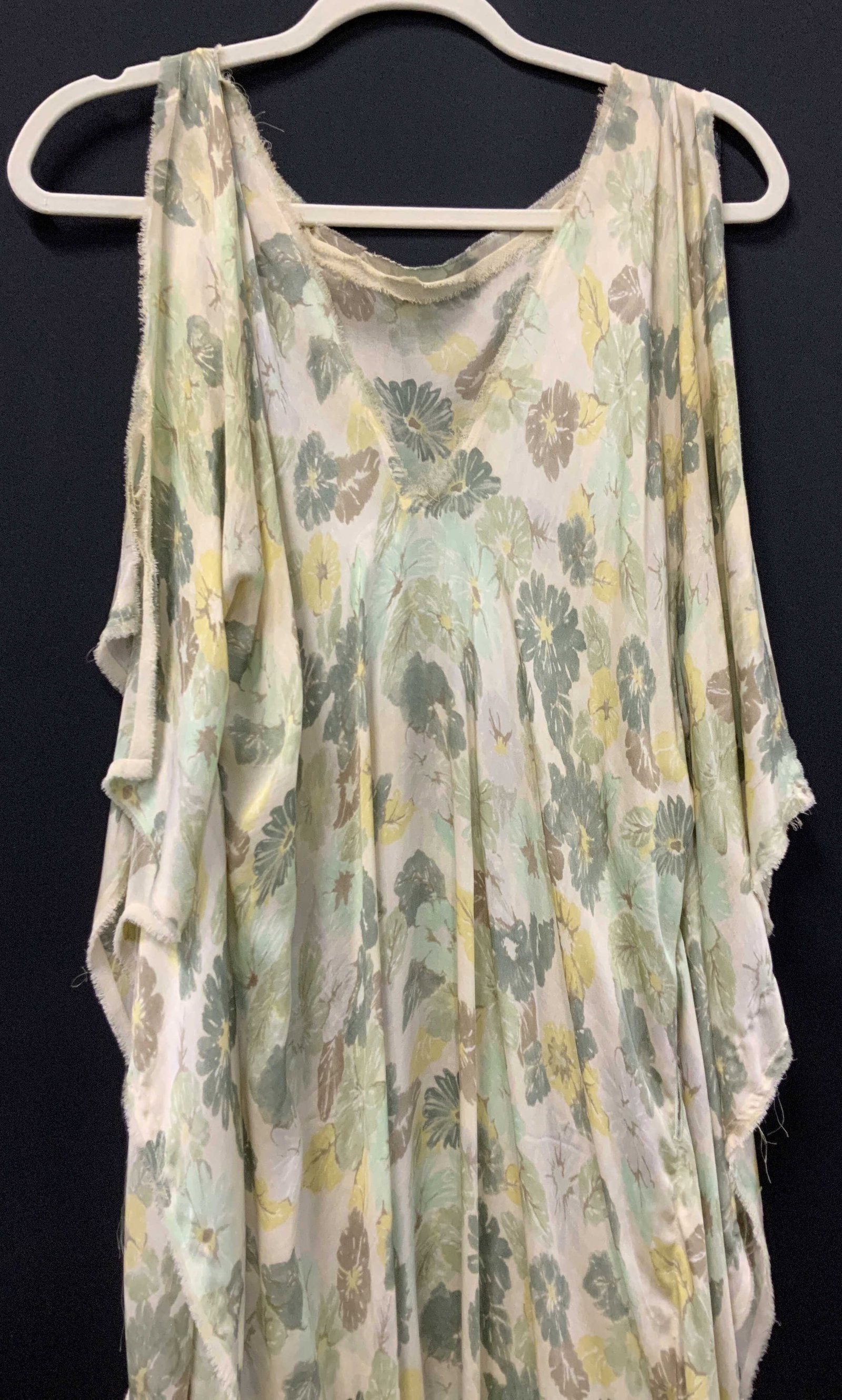 Silk Floral Muumuu w Fringe: Vintage cream toned silk muumuu/ caftan with green and yellow pastel flowers, V neck, and wide open arm holes. Total hem fringe. Holes for a belt. 48 in waist circumference. Some loose thread to be sn