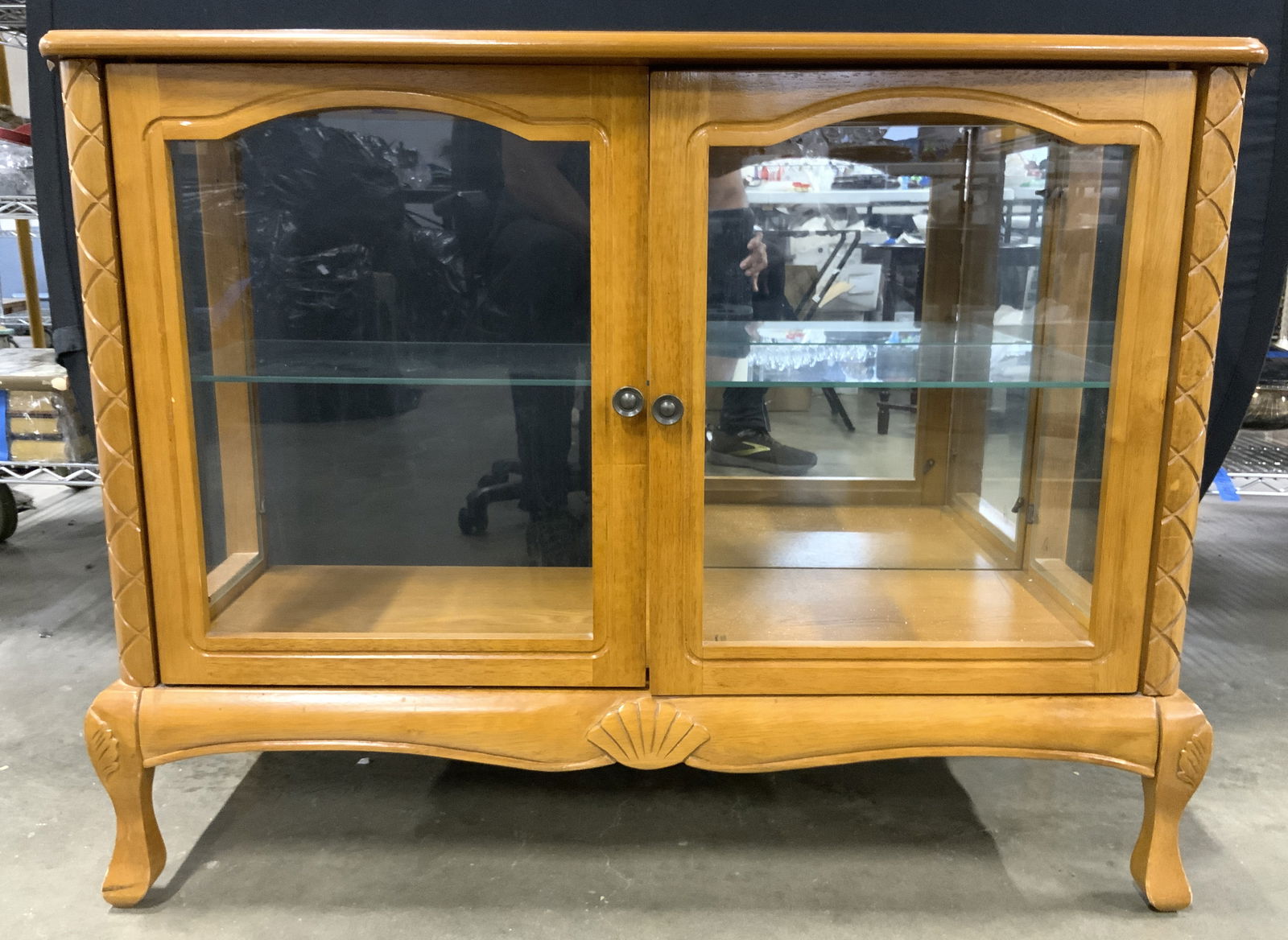 Vintage Queen Anne Style Curio Cabinet: Cabinet has angular Queen Anne style feel. Piece appears to be wooden possibly veneer. Curio cabinet has glass inserts to top & includes interior glass shelf. Doors and sides are windowed. Backside of