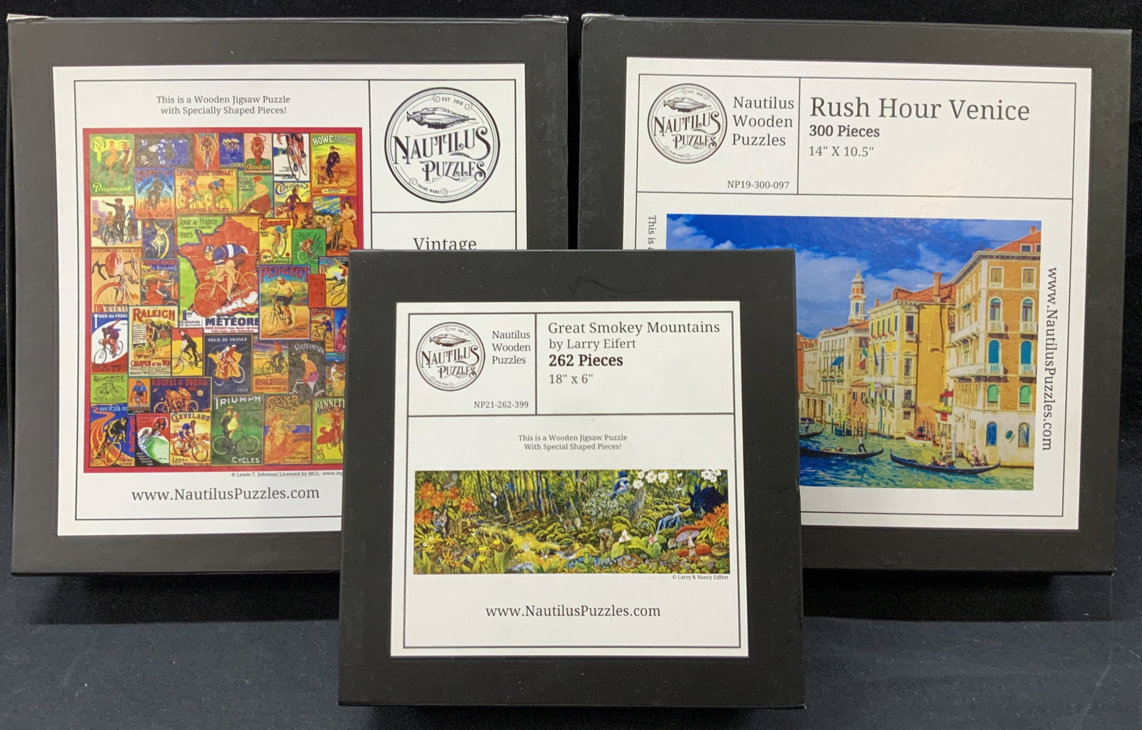 3 Nautilus Wooden Puzzles: Set of 3 wooden puzzles. 1 displays vintage tour De France, 500 pieces 14 x 17.5. 1 displays Rush Hour Venice, 300 Pieces, 14 x 10.5 inches. And the last depicts Great Smokey Mountains by Larry Eifert
