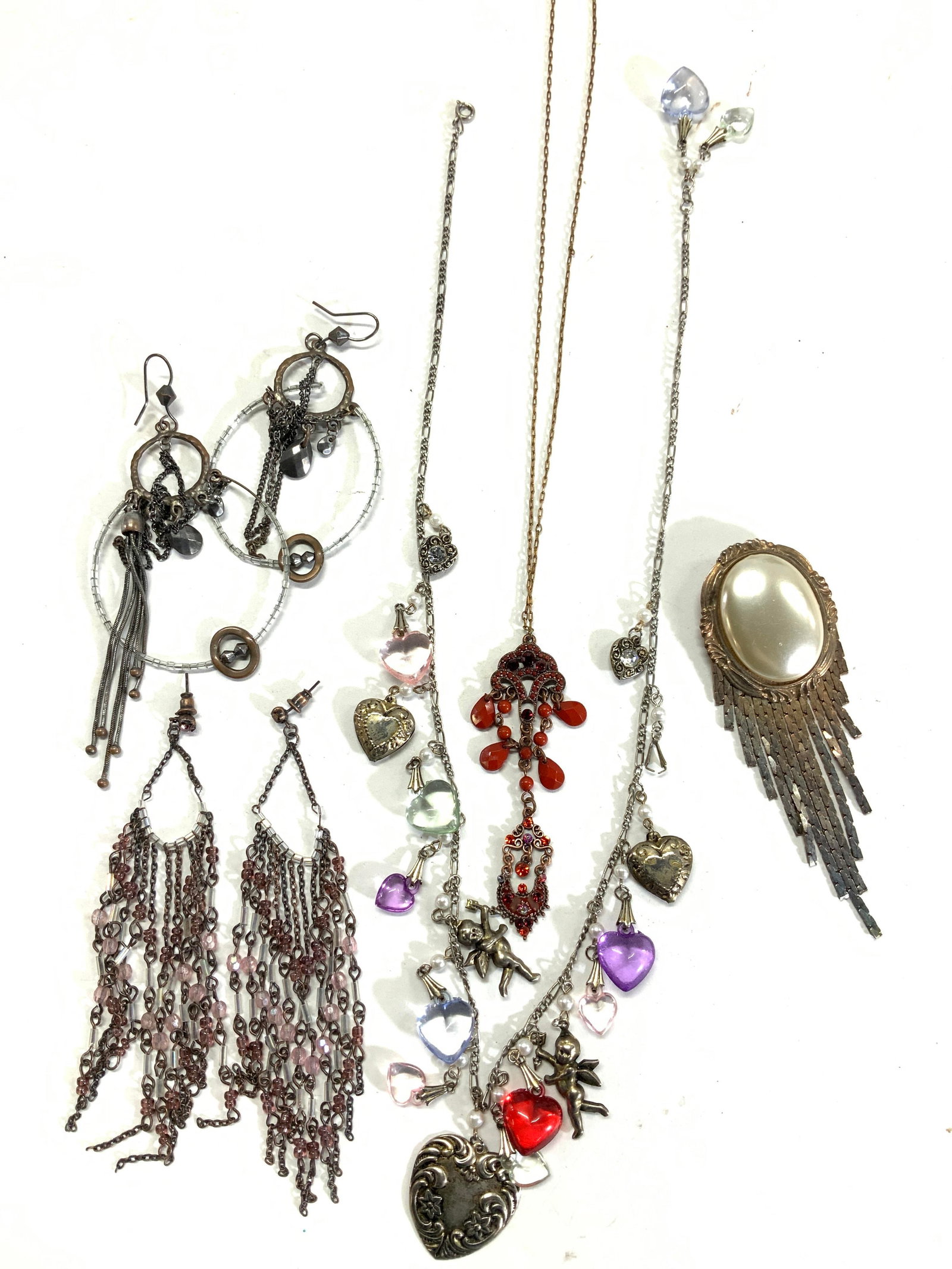 Lot 6 Victorian Style & Sculptural Fashion Jewelry: 2 fashion necklaces, 2 pairs of earrings, 2 faux Pearl brooch with flat chain tassels. Brooch measures 4.5 x 1.5 in. Red Victorian Crystal Necklace with gaggle clasp, 16 in. L Charm necklace with cher