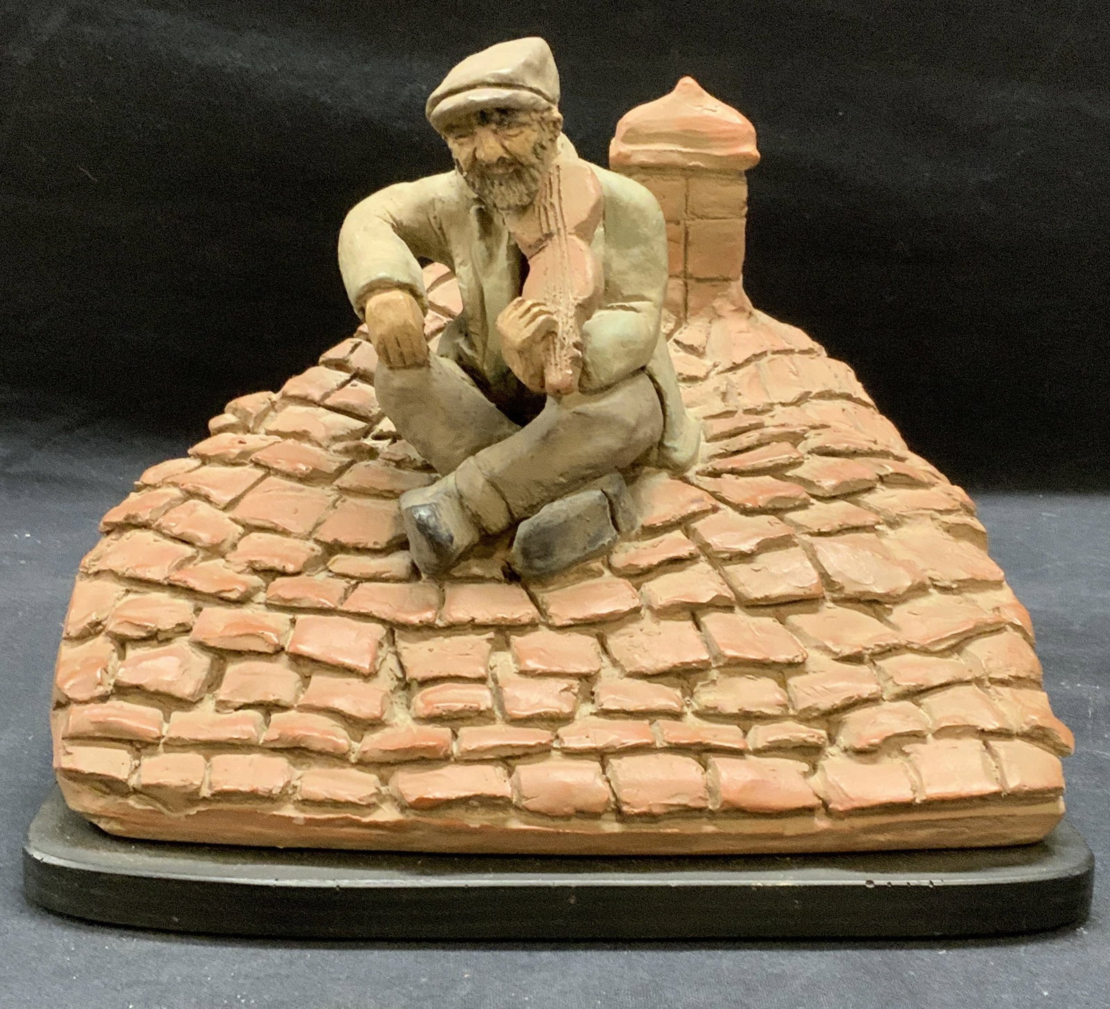 Signed Bernardi Fiddler On The Roof Sculpture: Signed Sam Bernardi Fiddler on the Roof ceramic sculpture. Signed to reverse. Dated 1966. Surface wear consistent with exposure. Piece has weight. Measures approx. 9 x 8.5 x 7.5 inches. Sam Bernardi, 