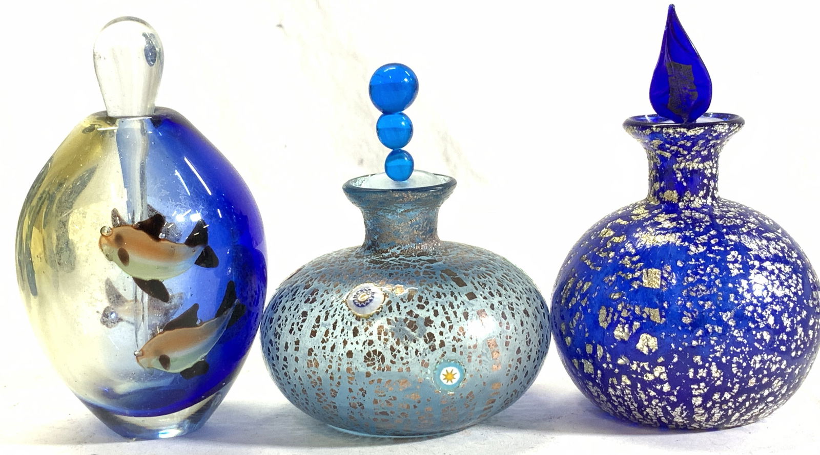 Lot 5 Murano Glass Perfume Bottles, Swordfish,: Murano hand blown glass perfume bottles and swordfish sculpture. All encompass 24 k gold flecks or bronze flecks. One perfume bottle is cobalt blue ( 4.5 x 2.75 in. Ht x W) . Light blue Millefiori bot