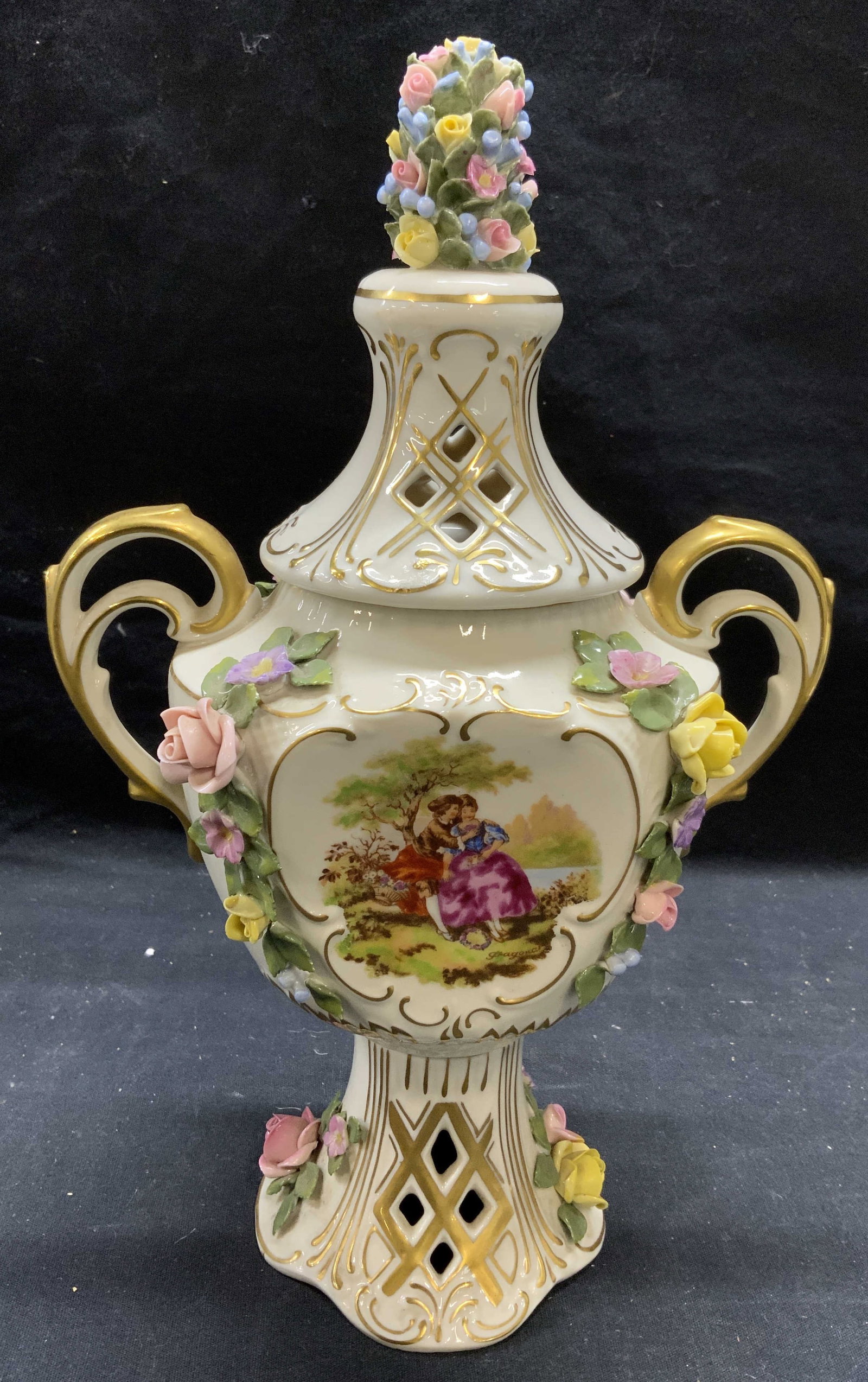 Vintage Capodimonte Gilt Porcelain Urn: Vintage Capodimonte gilt porcelain urn with figural and floral motif. Trademarked to underside. Made in Italy. Some surface wear consistent with exposure. Measures approx. 7.25 x 11.5 inches. Capodimo