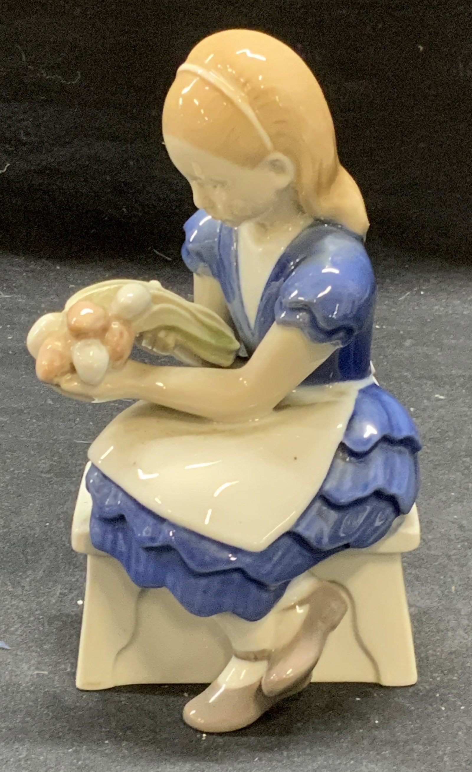 B&G Copenhagen Porcelain Figurine of a Girl: B & G Copenhagen porcelain figurine of a girl holding flowers. Trademarked to underside. Made in Denmark. Some surface wear consistent with exposure. Measures approx. 3 x 3 x 6 inches. B and g Copenha