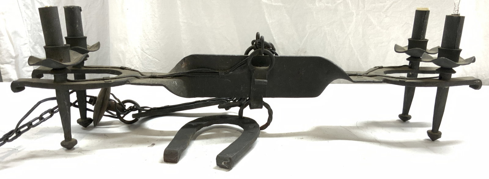 Vtg 4 Arm Iron Chandelier W Horseshoe Structures: Chandelier is vintage possibly antique. Piece is iron. Chandelier has horseshoe structures and long chain link. Piece has 4 arms. Chandelier measures approx 27.5 inches long 6.5 inches deep. Chain on 