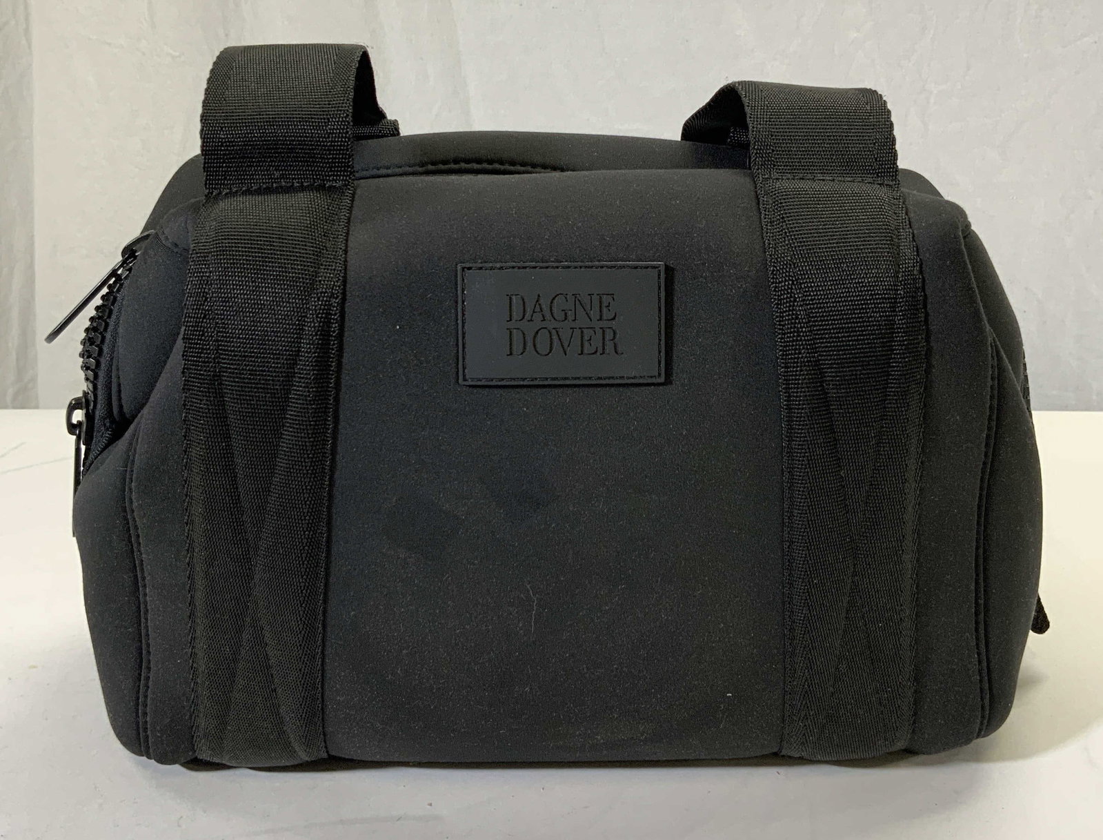 DAGNE DOVER Nylon Carryall Bag: Front of bag is inscribed DAGNE DOVER. Bag is black toned and nylon. Interior has zippered pocket, 2 mesh pockets & 1 additional pockets. Bag measures approx 17 inches tall 13.5 inches wide 5.5 inches