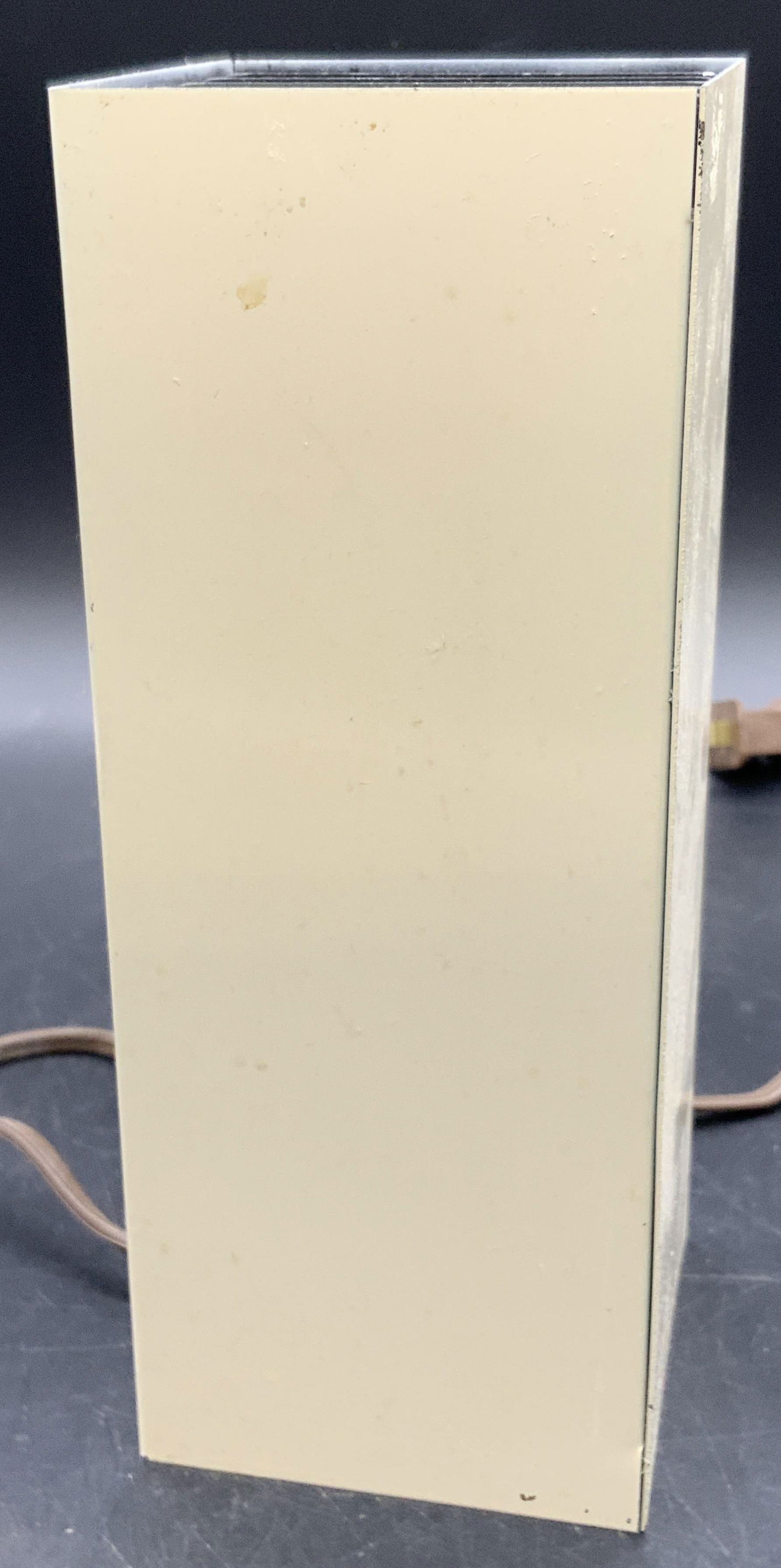 Vintage Rectangular Metal Table Lamp: A vintage rectangular metal table lamp. Black metal grid piece to the top is removable. Neutral toned metal. Brown hued cord. Measures approx. 8H x 3W in. Some surface wear and discoloration present.