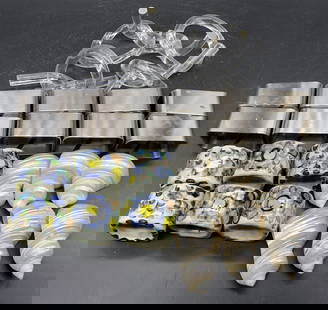 Group Lot Napkin Rings, Signed & More: A group lot of napkin rings crafted from shell, stainless steel, ceramic, and acrylic materials. Ceramic pieces are hand painted and signed, illegible. Stainless steel pieces are marked STAINLESS STEE