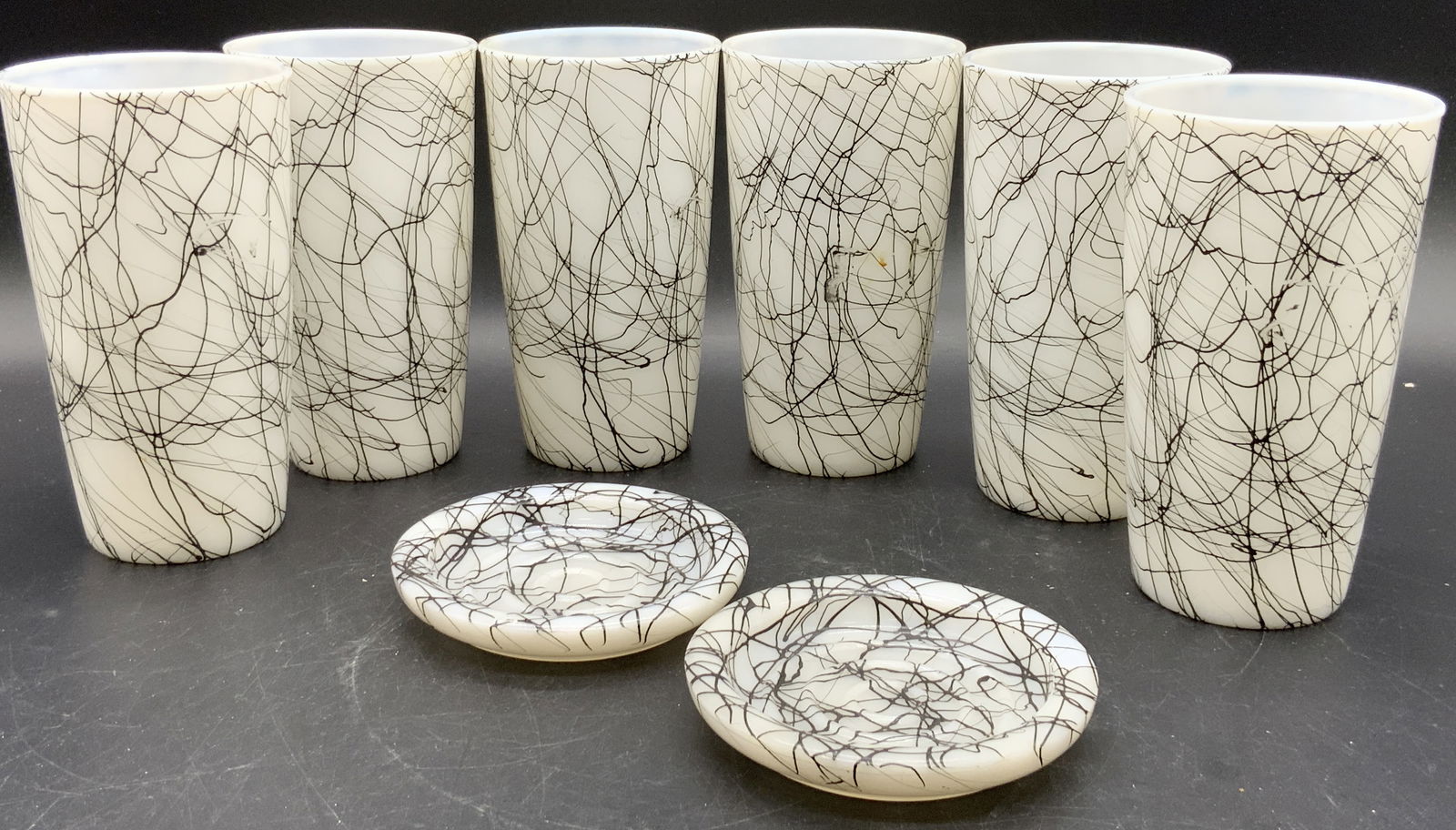 Set 8 Vintage Mid Century Black Drizzle Glasses: Set consists of six glasses and two coasters. Vintage midcentury white glasses and coasters with a black drizzle drip pattern. Drip is slightly raised off the surface. Glasses measure approx. 5H x 3W