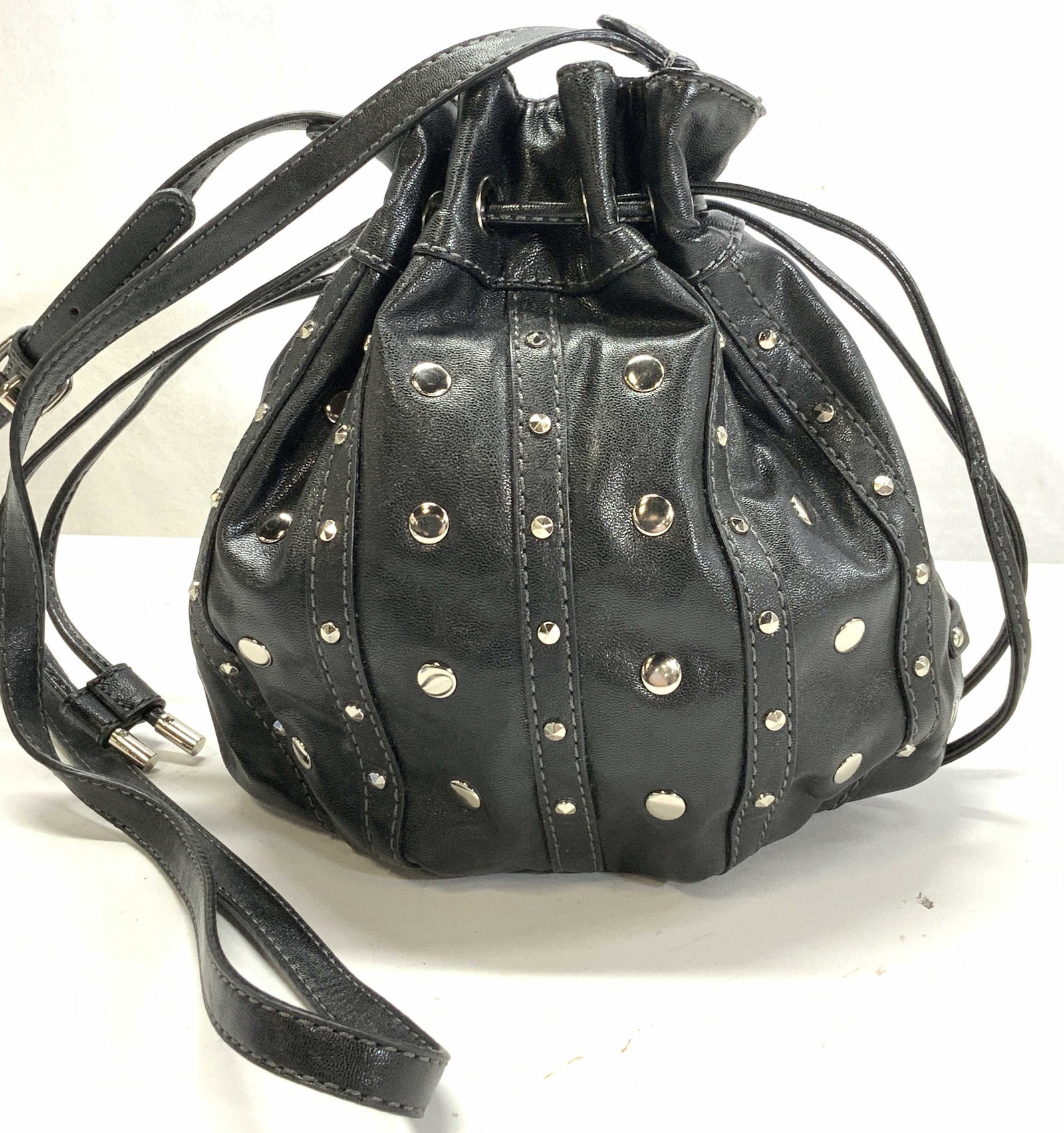 Nine West Faux Leather Bucket Bag: Nine West Studded Faux Leather Cinch Bucket bag shoulder bag in black. Made of man made materials, adjustable length strap, 23.5 in. Drop longest length or shorter. Signed Nine West. Interior animal p