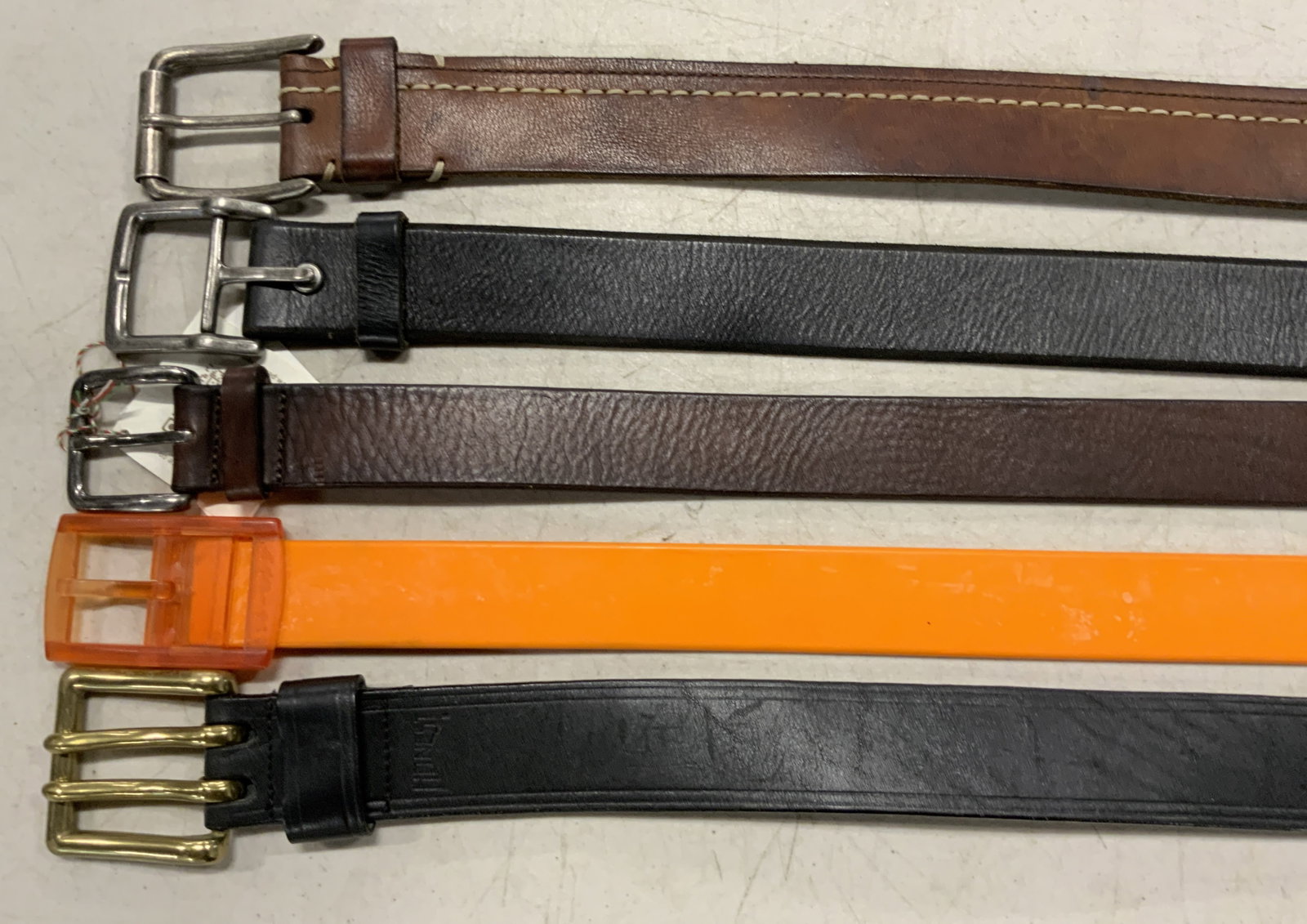 5 Belts, TIEUPS, WILL, HONEST, EMILIO SCOTTI &more: Brands include TIE-UPS, WILL, HONEST, EMILIO SCOTTI and more. Some pieces are crafted from leather, Sone pieces are crafted in Italy. Primarily brown and black hues, one bright orange belt. Orange bel
