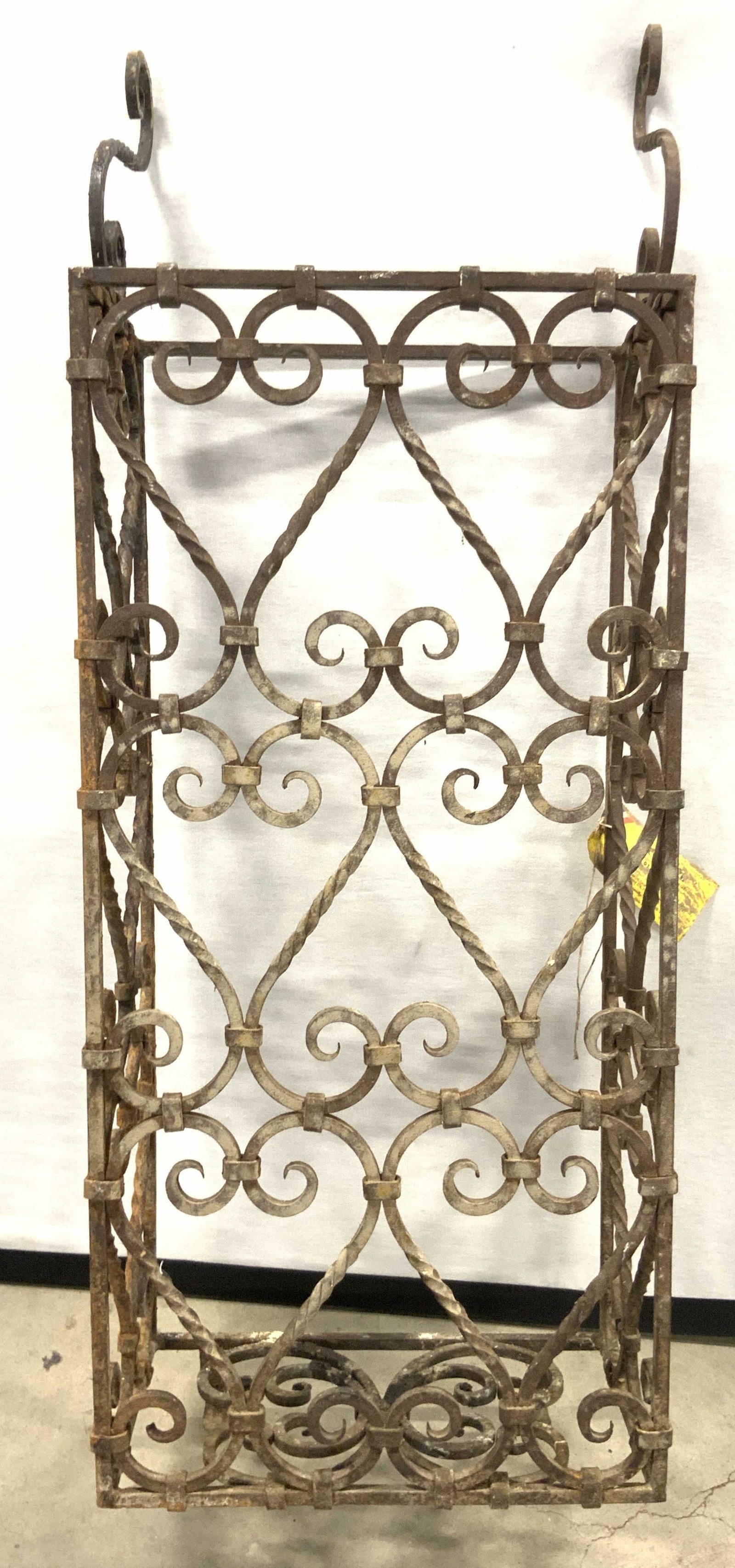 CAMARD Vintage French Iron Window Cover: A vintage French iron window cover. Twisted and curled metalwork designs. Weighty piece. Tag to side reads CAMARD MADE IN FRANCE. Some residue present. Some wear consistent with age, use, and exposure