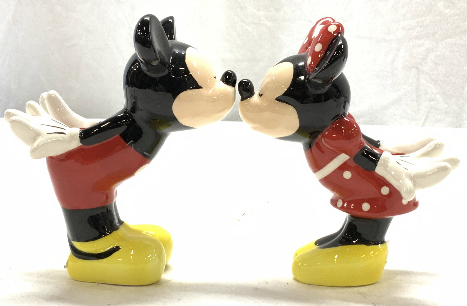 Pair Jerry Leigh Mickey & Minnie Mouse Shakers: Disneys Mickey and Minnie Mouse Porcelain Salt and pepper shakers with rubber plugs. Like new, possibly never used. 5 x 3.25 in. Sticker label reads ‘Jerry Leigh Salt and Pepper Shakers, Disney Tabl