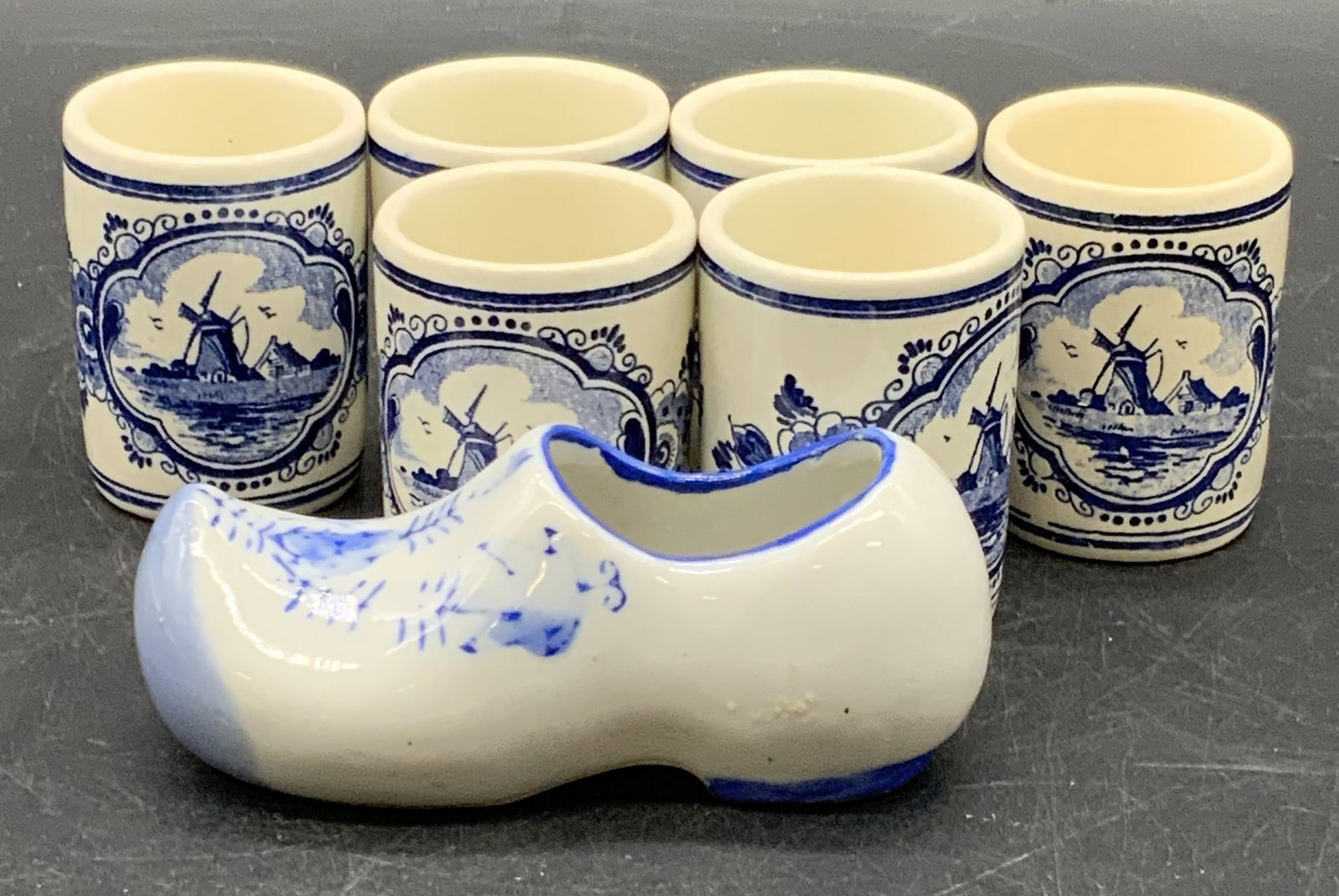 7 Hand Painted Blue & White Ceramics, DELFT &more: A lot of six hand painted blue and white ceramic shot glasses featuring windmills to the obverse and the word VANDERMINT to the reverse. Undersides signed HAND PAINTED DELFT HOLLAND. One hand winged b