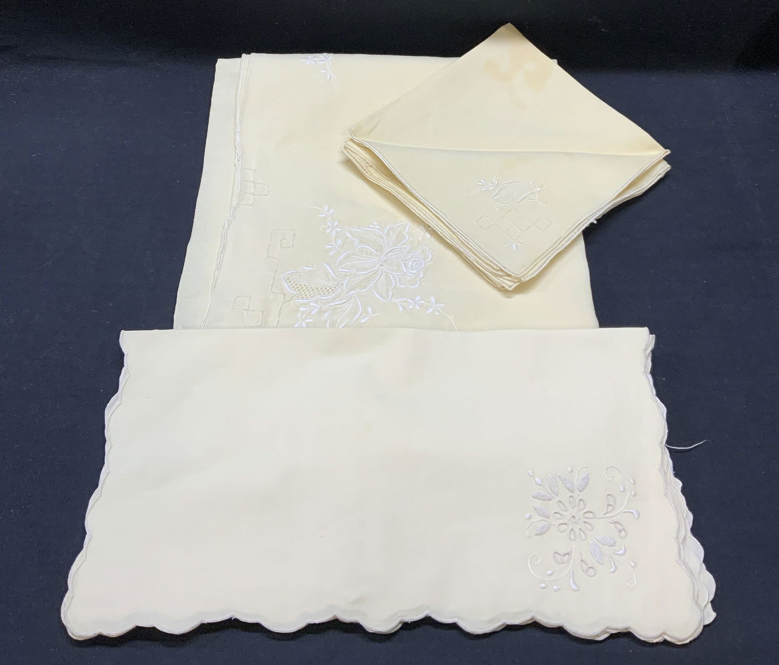 Lot 15 Cream Cotton Tablecloth & Napkins: 1 cream toned embroidered tablecloth (approx. 68 x 50 inches) with floral motif and 6 matching napkins with leaf motif (approx. 16.25 x 17 inches). 8 cream toned embroidered napkins with floral motif,
