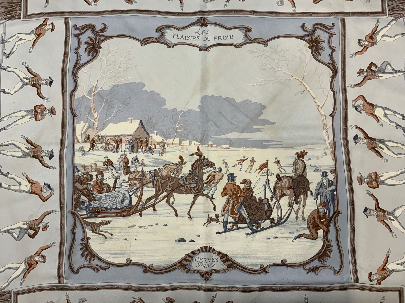 Hermes Gygkar Plaisir De Froid Silk Scarf, France: Hermes Les Plaisir Du Froid silk scarf with winter scene figural motif in hues of blue-grey and brown. Made in France. Designer label to lower center. Art designed by Hugo Gygkar. Some blemishes to ma