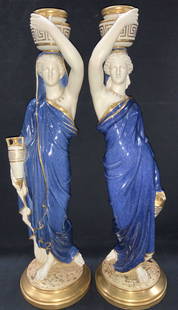 Pr Royal Worcester GrecoRoman Porcelain Figures XL: Pair of Greco Roman figures depicting two women in blue robes with gilt trim as they hold up pottery on their heads and hold another pot in their hands. Both Marked Royal Worcester, England on undersi