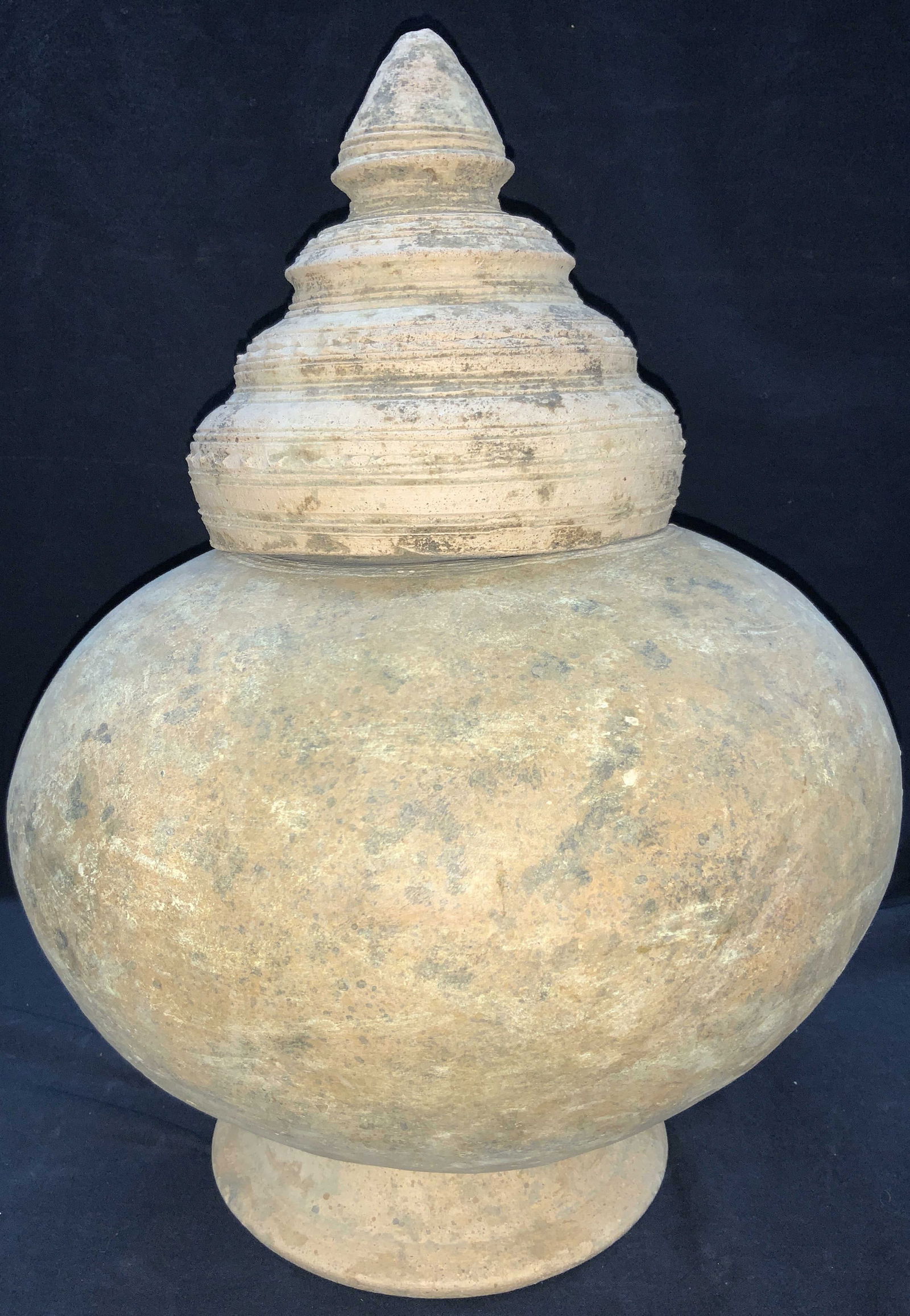 17 Inch Tall Vintage Pottery Vessel: 17 inch tall vintage pottery vessel made of tan toned clay with removable coil top. Approximately 17 inches tall and 36 inches around. Moderate surface wearing to clay and to interior Hold on the bott