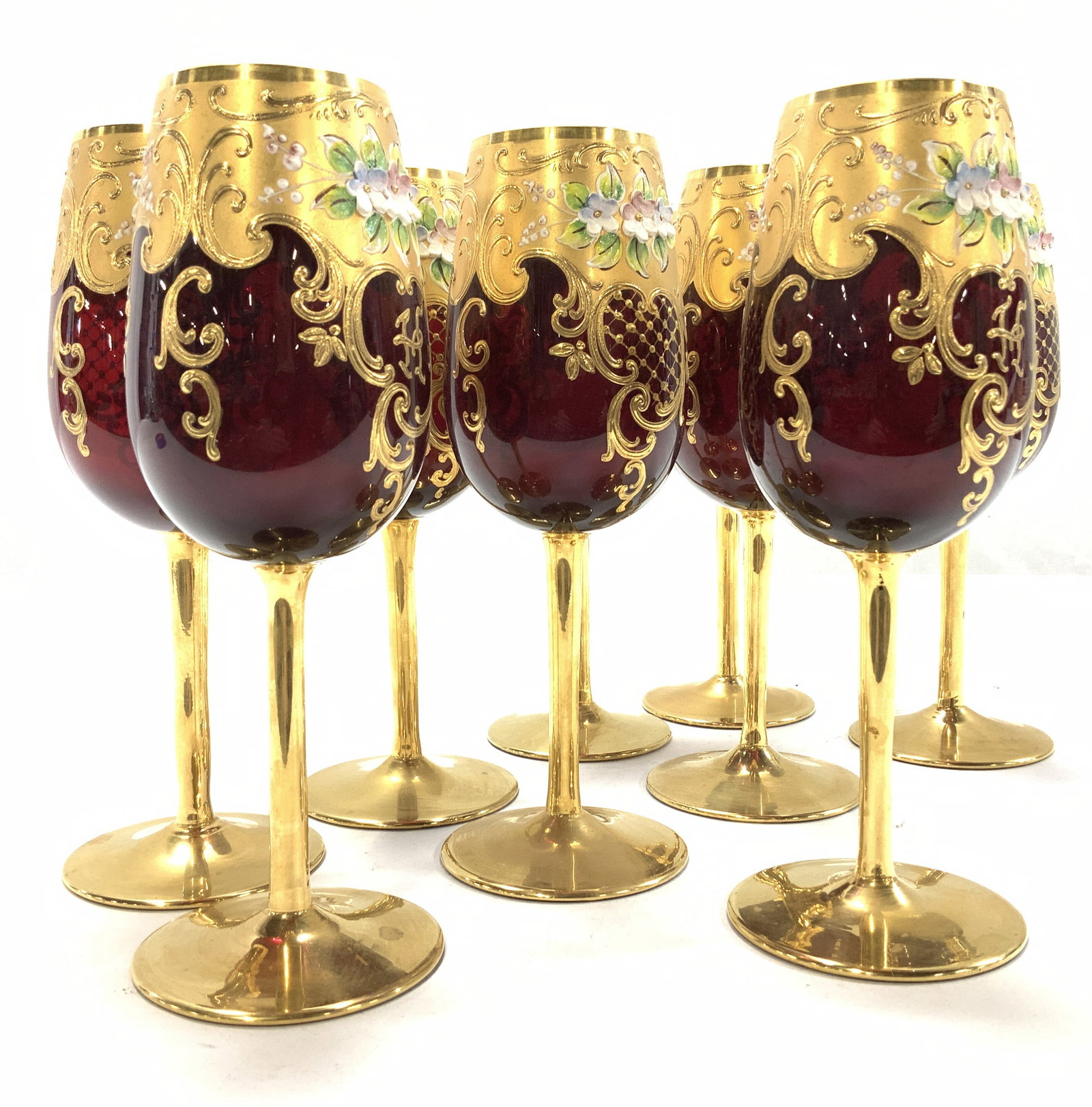 Set 9 Ruby Red 24K Gilt Bohemian Crystal Glasses: Hand painted Ruby Red Bohemian stemware , long thin stem , 24k gold hand painted scroll decor with paste up flowers , measure 8.25 x 3 in. These hare hand blown crystal glasses. Bohemian Ruby red luxu