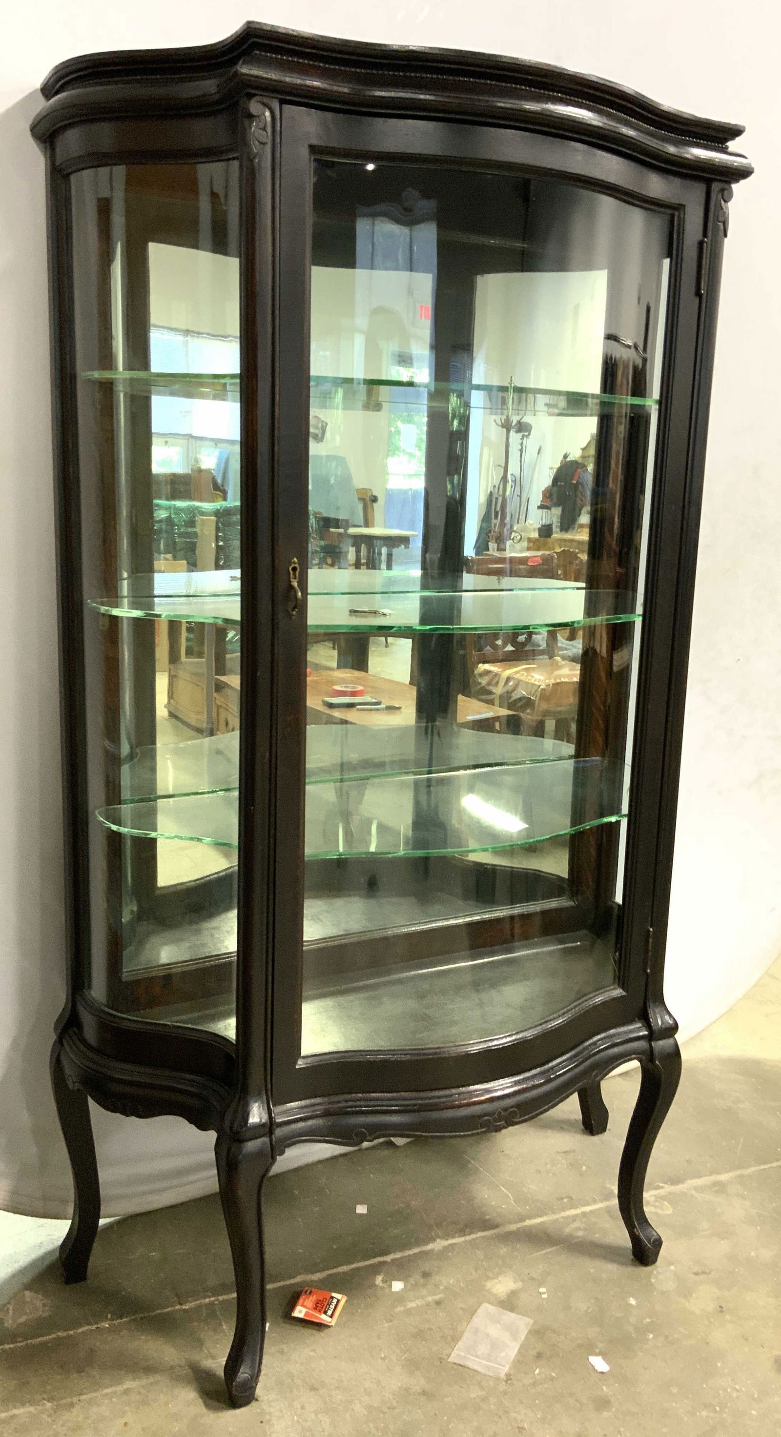 Vintage Mahogany Serpentine Curio Cabinet: Curio cabinet is wooden, appears to be mahogany. Piece has windowed door and mirrored area. Interior includes 3 glass shelves, & carved wooden Queen Anne legs. Cabinet measures approx 61 inches tall 3