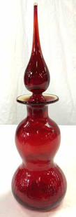 BLENKO Mid Century Art Glass Decanter W Stopper: Decanter appears to be BLENKO Decanter is red toned & glass. Piece appears to be hand blown due to pontil on underside. Decanter includes stopper. Piece measures approx 13 inches tall 4 inches wide. D