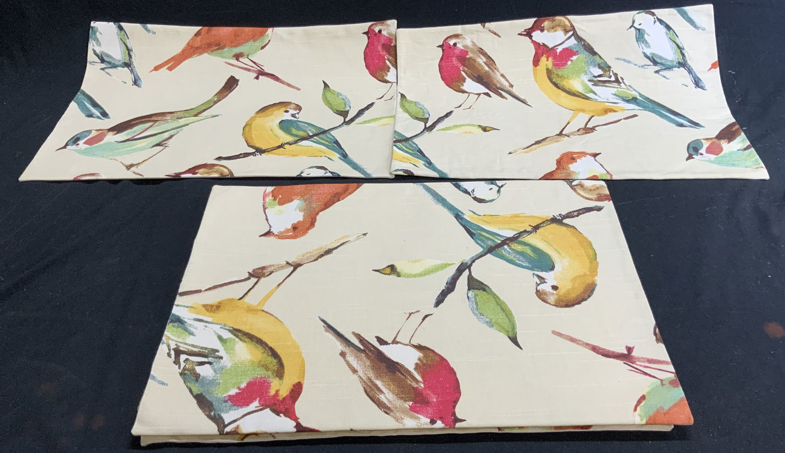 Group Lot 14 Bird Motif & Pebbled Placemats: A group lot of fourteen placemats. Six Fabric bird placemats have Eileen Duffy tags to the reverse. Multicolored. Bird placemats measure approx. 13L x 18W in. Eight pebbled placemats have a stiffer fo