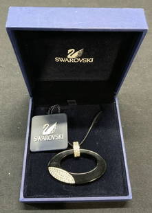 SWAROVSKI Crystal Pendant Necklace New in Box: Swarovski crystal pendant necklace on cord. New in original box with tag. Black acrylic oval shaped pendant with crystal decoration. Pendant measures approx. 1.75 x 1 inches. Cord length approx. 36 in