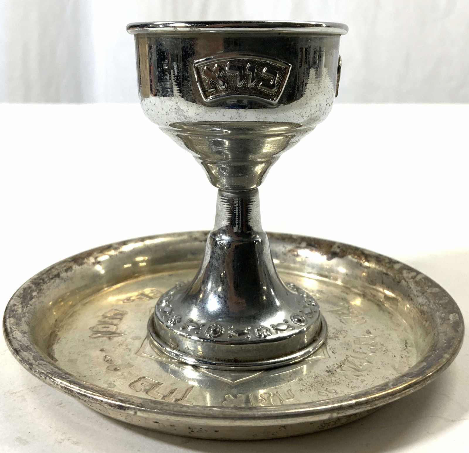 Vintage Silver on Copper Judaica Goblet & Coaster: Underside of coaster readS SILVER ON COPPER. Each piece appears to be vintage. Coaster has floral detail & Hebrew characters. Goblet is silver toned with Hebrew characters. Coaster measures approx 4.5
