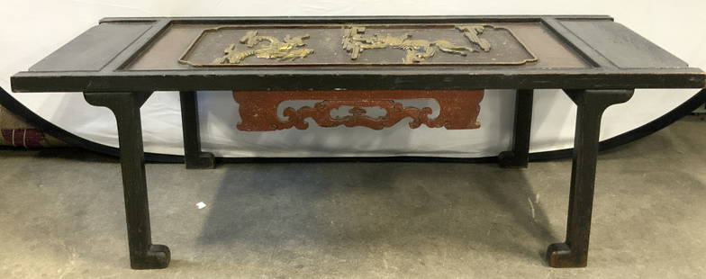 Vintage Carved Wooden Fu Dogs Asian Coffee Table: Carved wooden coffee table with L shaped feet and raised Fu dogs in gold on the center of the table with Asian scroll designs on underside. Approximately 18 x 44.5 inches and 14 inches tall. Evident w