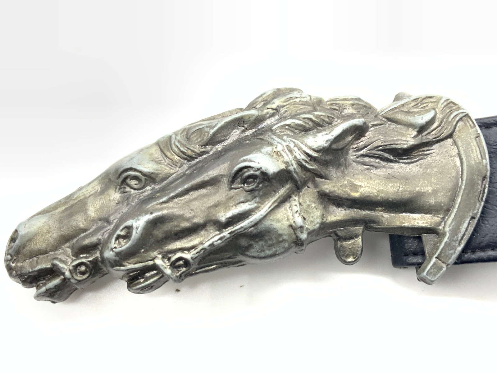 Blue Leather Belt W Pewter Horse Buckle: A blue leather made fashion belt with a 5 inch long pewter made buckle with the images of two horse heads. Vaguely marked Accurate on underisde. Belt is approximately 30 inches long and 1.75 inches wi