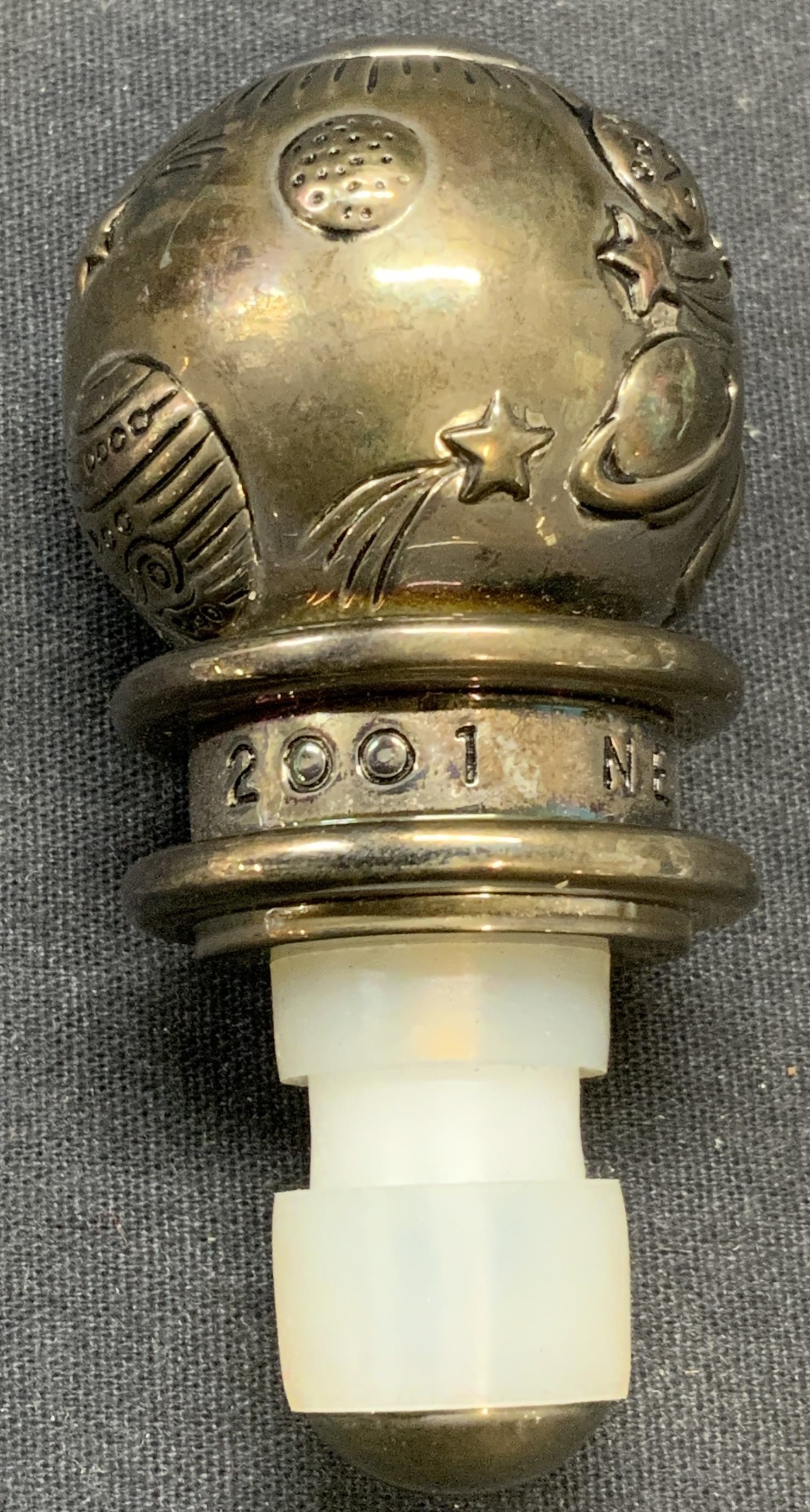 Neiman Marcus 2001 Silver Plate Bottle Stopper: Neiman Marcus 2001 Out of This World silver plated bottle stopper with planet motif. Piece is heavy. Measures approx. 3 x 1.5 inches. Some surface wear consistent with exposure. NEIMAN Marcus, NEIMAN 