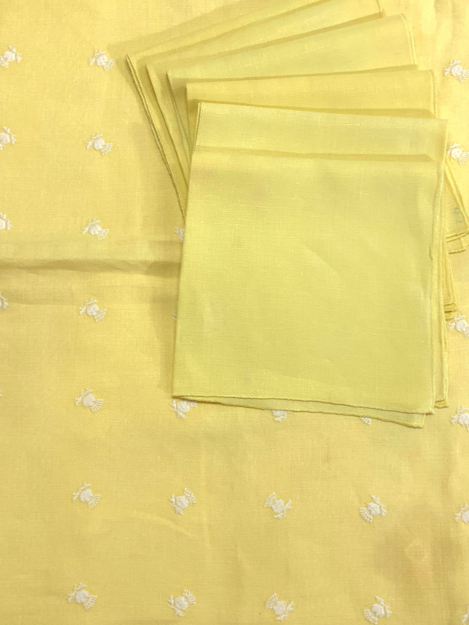 Embroidered Yellow Linen Tablecloth & Napkins 7: Yellow linen tablecloth with white embroidered flowers and white trim. Neatly pressed. A few blemishes . Measures 48 x 23.5 in. Set 6 yellow linen napkins. A bit darker than the tablecloth. Measure 16