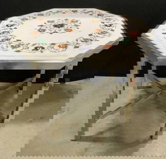 Octagonal Inlaid Stone Mosaic Top Metal Side Table: An octagonal side table comprised of an inlaid stone top and a silver tone metal base. White hued stone inlaid with blue, orange, and green stones. Floral and foliage designs. X shaped stretcher to th