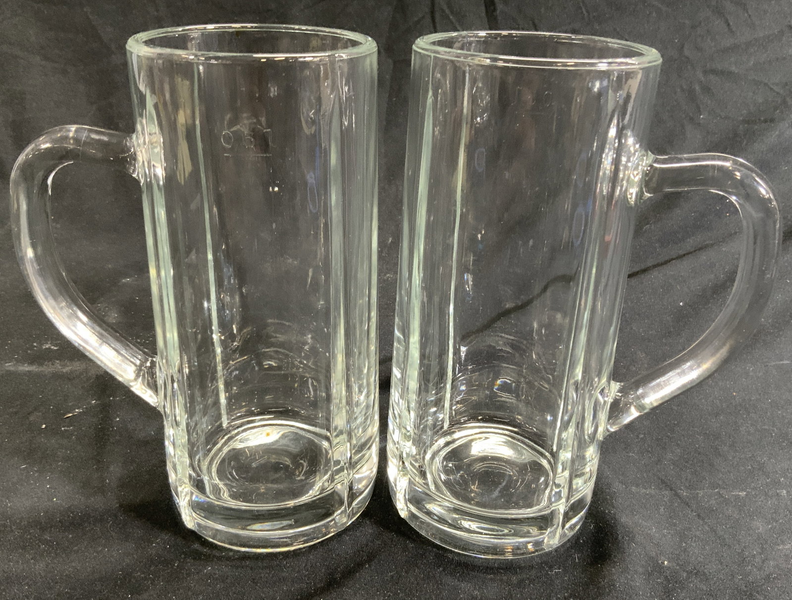 Pair Glass Pitchers Mugs Vessels: Lot includes 2 pitchers. Each are glass. Pitchers each are marked at 0.5 L. Vessels each have handles. Each measures approx 7.25 inches tall 5 inches deep 3.25 inches wide. Pitchers, mugs, vessels, gl