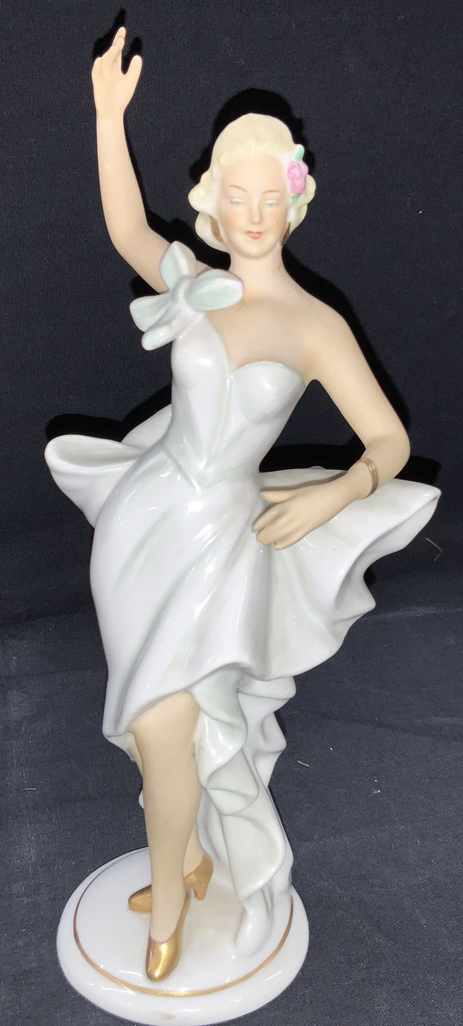 SCHAUBACHKUNST Porcelain Figure, Germany: Marked on underside SCHAUBACHKUNST, Germany. Depicts a woman in a white strap less dress with a long ruffled skirt and blonde hair. Approximately 9.5 inches tall. Minor wearing to porcelain. SCHAUBACH