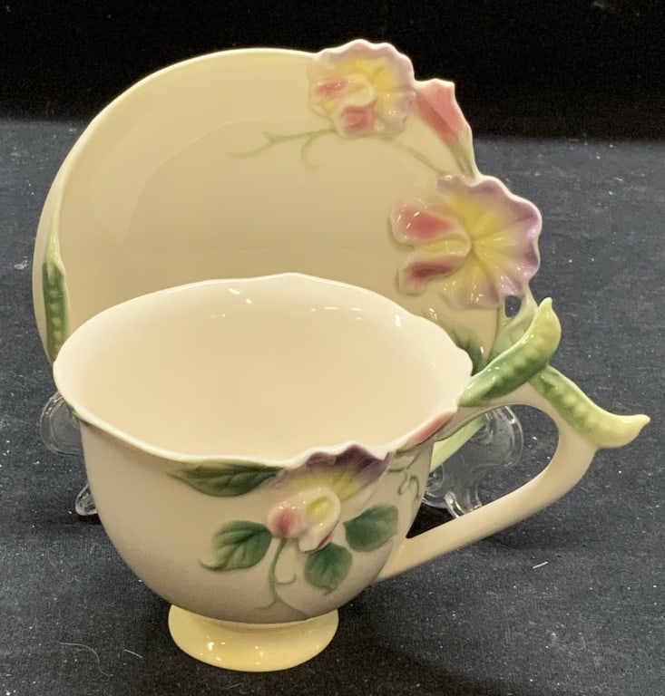 Franz Floral Porcelain Teacup & Saucer: Franz floral porcelain teacup and saucer. Trademarked to undersides. Some surface wear to each consistent with exposure. Saucer measures approx. 4 3/8 inches diameter. Teacup measures approx. 3.25 x 2