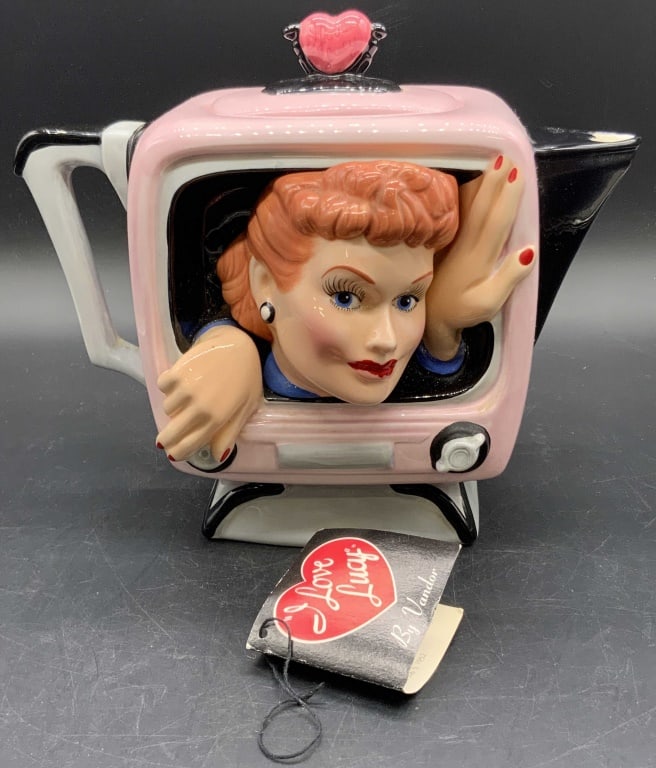 VANDOR I Love Lucy 3D Ceramic Teapot, Org Tags: A 1996 ceramic I Love Lucy 3D teapot. Primarily pink, black, red, and white hues. Lucy is depicted coming out of the tv screen, one hand on a dial. Underside possesses original stickers and stamp read