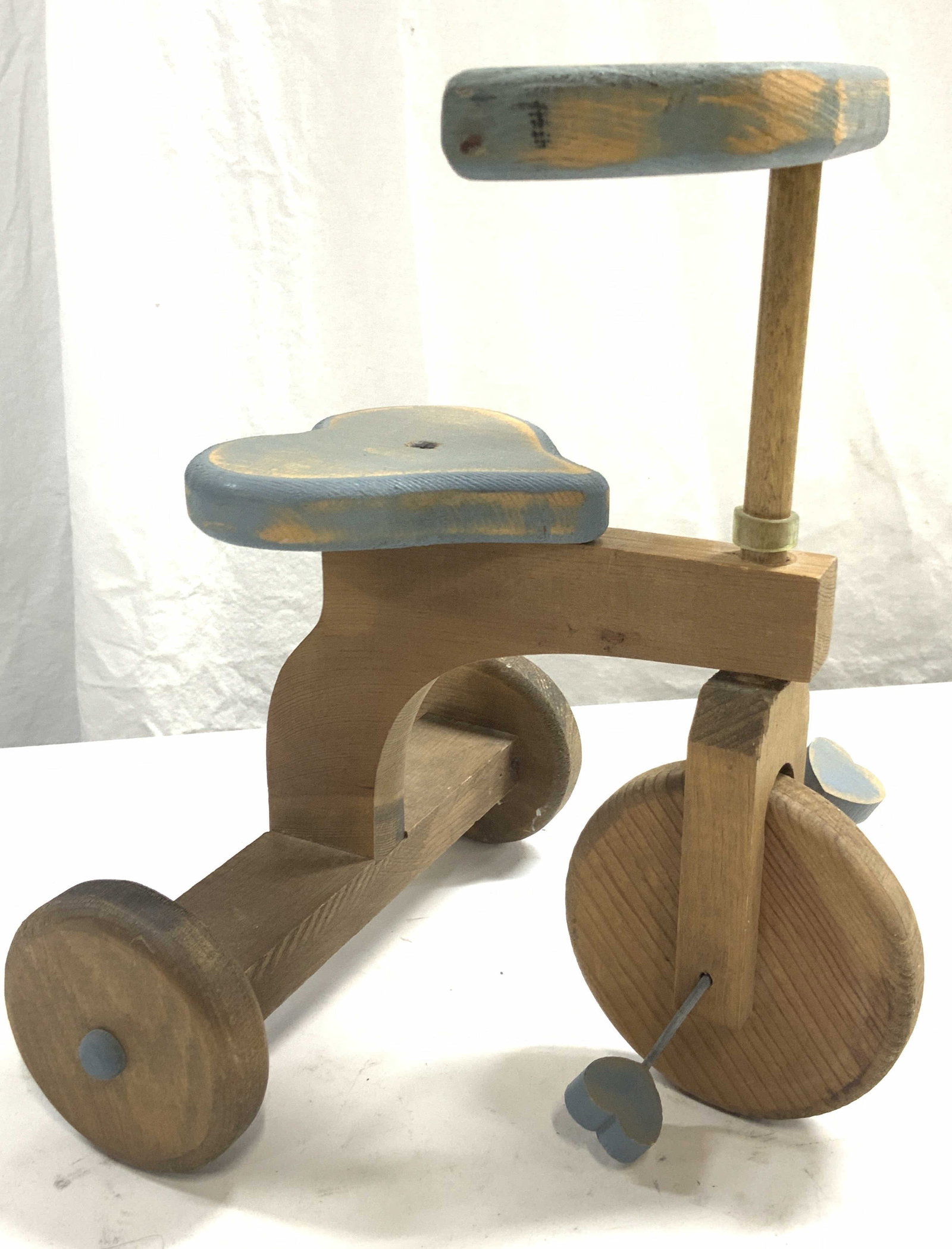 Old Creek Merc. Wooden Doll Tricycle: Stamped on underside Old Creek Merc. Painted wooden doll tricycle with natural wooden frame and painted blue seat and handles with bear shaped seat. Approximately 11 inches tall and 10 inches long. Ev