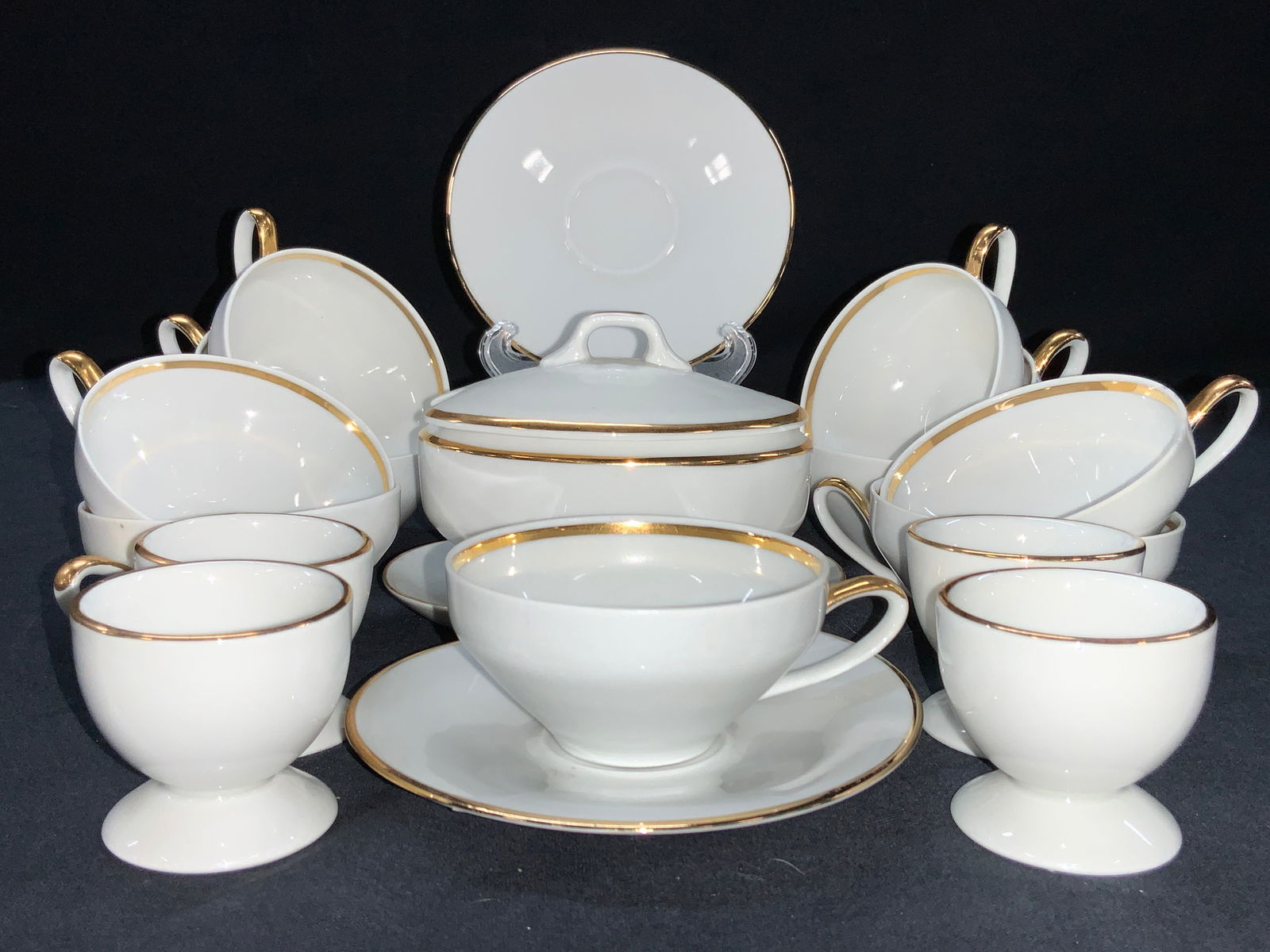 24 ZEH SCHERGER Fine China Tea Set: Set of 24 white and gilt zeh Scherger fine china table accessories. 11 demitasse cups 1.5 inches tall and 3 inch diameter. 8 saucers, at 4.5 inch diameter. 1 sugar bowl with affixed dish, approx 4 inc