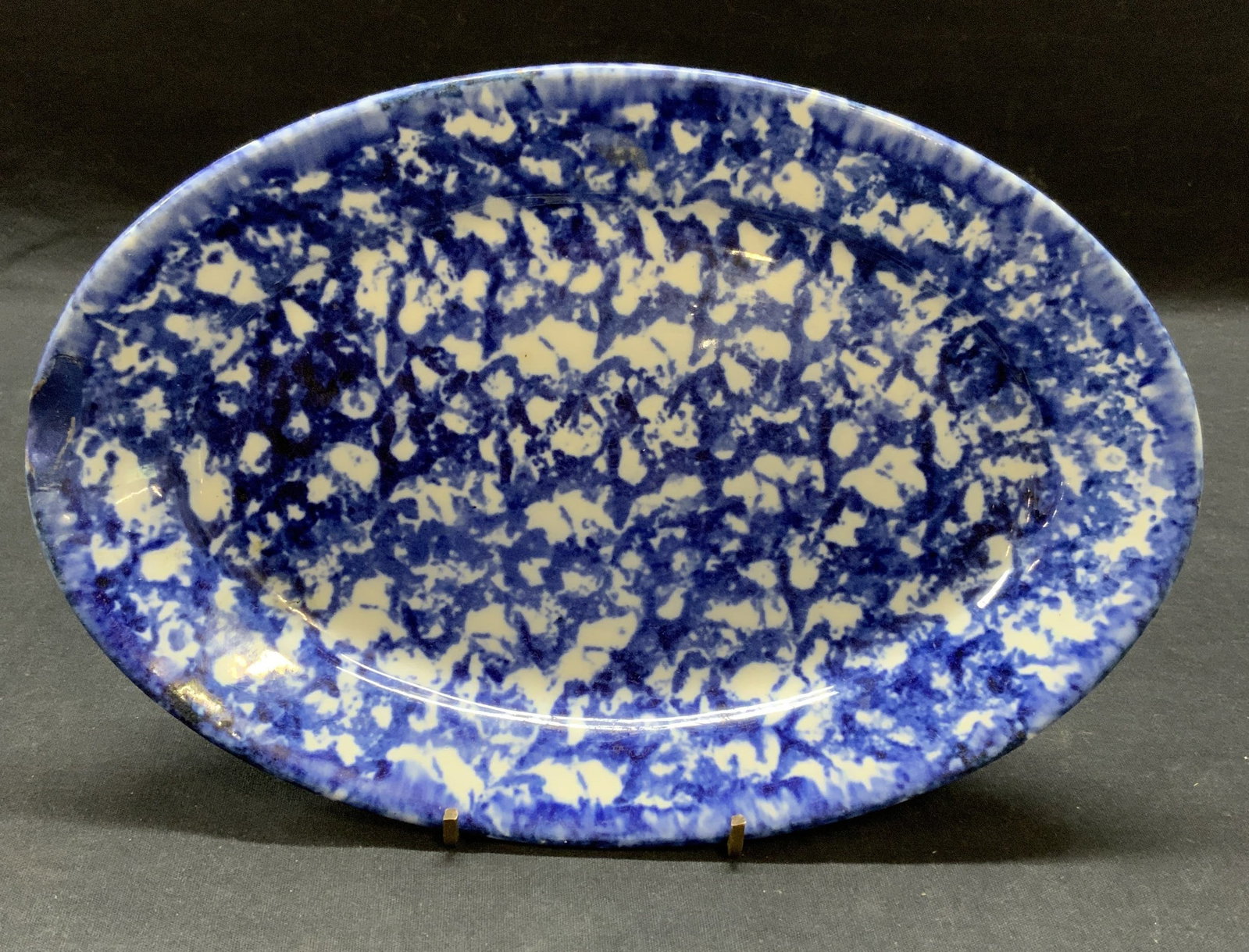 Vintage Ceramic Blue Spongeware Plate: Vintage ceramic blue and white spongeware plate. Measures approx. 10 5/8 x 7.25 inches. Some surface wear consistent with exposure. Spongeware, spongeware plate, ceramic plate, blue plate, vintage tab